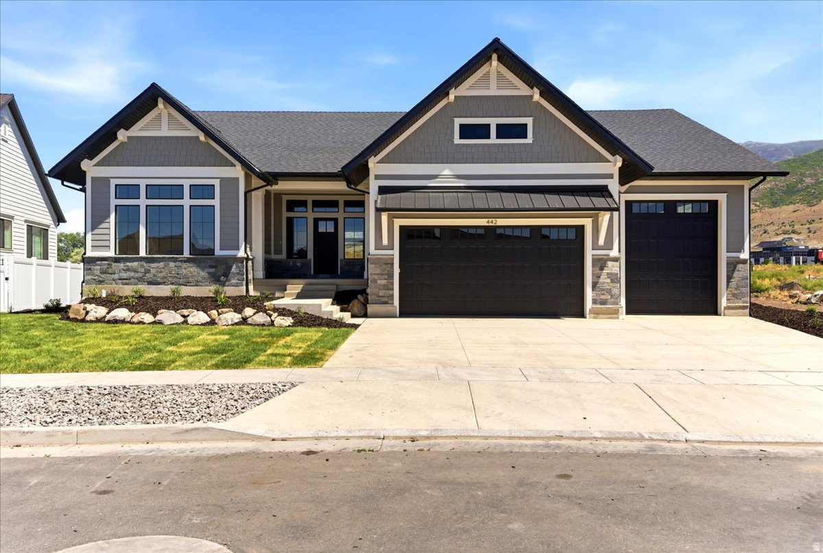 Stunning Farmington craftsman new build with 4,797 sq ft, 4 beds, 3 baths, and exceptional finishes throughout. Fully landscaped yard features a lush sod lawn in front and back, trees surrounding the back yard for privacy, natural boulder accents, and a covered trex deck with black iron railing and breathtaking mountain views - perfect for outdoor living. Inside, coffered ceilings with rich faux wood beams flow through the open main level. The great room centers on a gas fireplace flanked by custom built-ins, while the gourmet kitchen impresses with two-tone cabinetry, a quartz island, 36" gas cooktop, double wall ovens, built-in refrigerator, subway tile backsplash, and a massive hidden-door walk-in pantry. The dining area is wrapped in windows with unobstructed mountain views. A dedicated office with French doors, built-in mudroom lockers, and a showstopper laundry room with full cabinetry, quartz counters, and utility sink add everyday function. The primary suite features a spa-inspired en-suite with dual vanities, freestanding soaking tub, and glass walk-in shower with floor-to-ceiling tile. The finished basement offers a full second kitchen with an island, a full theater room with projector, screen, and surround sound, and three additional bedrooms. 10' main level ceilings, 8' doors, 3-car garage, and walking distance to Station Park and Farmington High.