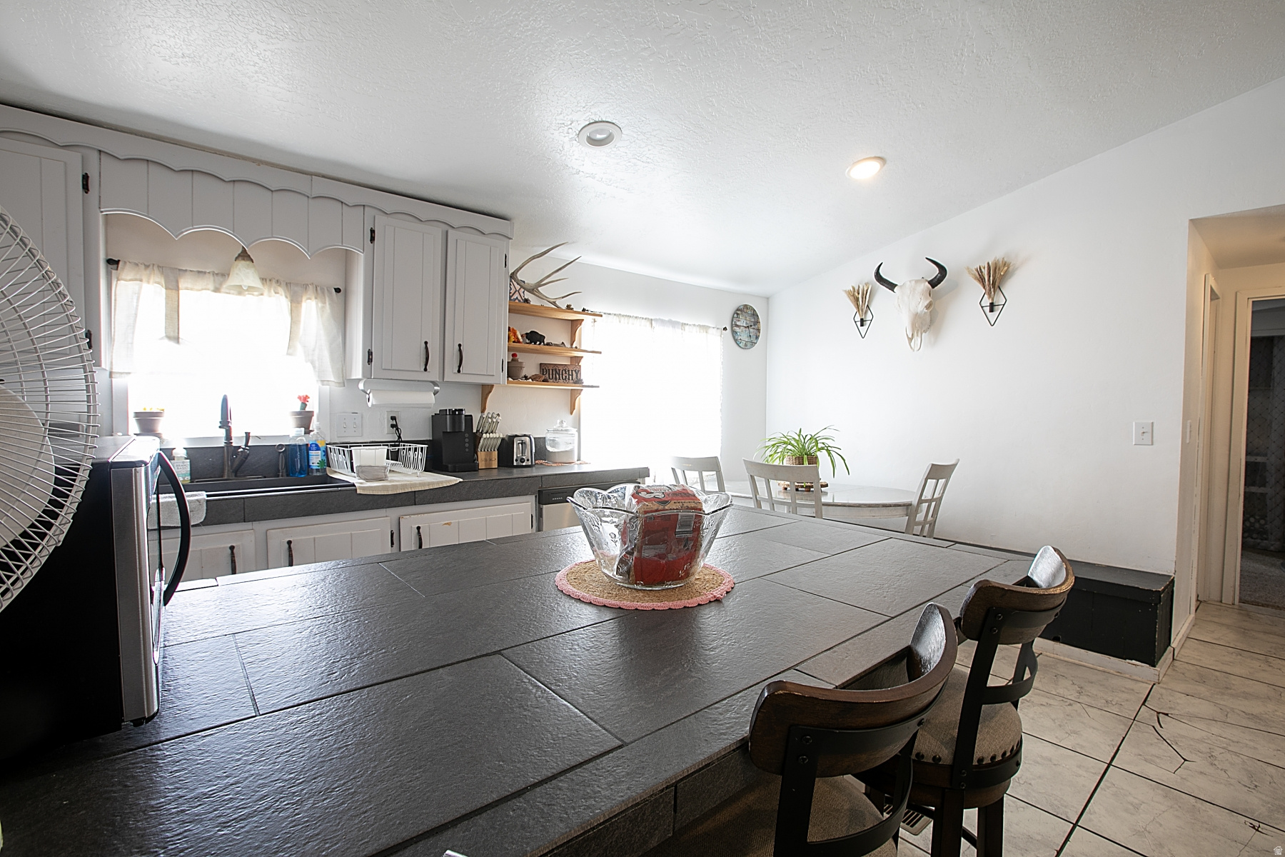 3-bed/2-bath home on nearly 5 fenced acres with mountain views. Wood stove in the garage, central A/C, heated workshop. Culinary water + private well. Livestock-ready. No HOA. Tankless water heater.