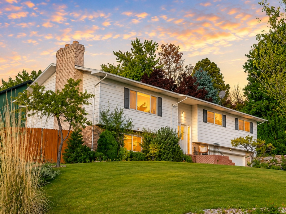 GRAND OPENING Saturday, June 6th from 1:00 p.m. to 3:00 p.m. Offered at $505,000, this beautifully maintained home in the highly sought-after Heather Hills neighborhood of East Layton offers the perfect blend of privacy, views, comfort, and outdoor adventure. Perched on an elevated corner lot directly across from the protected green space of Kays Creek, this property enjoys breathtaking mountain and sunset views with no future development to the west, creating a peaceful and secluded setting that is increasingly difficult to find along the Wasatch Front. Featuring nearly 2,100 square feet, this spacious home offers 4 bedrooms, 3 bathrooms, a 2-car garage, and multiple living spaces ideal for both everyday living and entertaining. The thoughtful layout includes three bedrooms upstairs, an additional bedroom in the basement, two separate family rooms, and two cozy fireplaces that create warmth and character throughout the home. Recent updates include fresh paint throughout the interior and garage, updated light fixtures, a newer air conditioning system, and a newer water heater, providing both style and peace of mind. Step outside to a beautifully terraced backyard designed for relaxing evenings, gardening, and entertaining while taking in the incredible sunset views and surrounding greenery. The elevated hillside setting offers a quiet, tucked-away feel while still being remarkably convenient to everyday amenities. Location is where this home truly shines, with quick access to I-15, shopping, dining, schools, and recreation. Hiking and biking trails leading into the Wasatch Mountains are just minutes away, while world-class skiing at Snowbasin Resort is approximately 26 minutes from your front door. Enjoy easy access to Pineview Reservoir for boating, paddleboarding, fishing, and summer recreation, while also being conveniently located between downtown Ogden's vibrant dining and entertainment scene and downtown Salt Lake City. Salt Lake City International Airport is also within easy reach for business or leisure travel. Homes in Heather Hills rarely offer this combination of views, privacy, outdoor access, updates, and convenience at this price point. Don't miss your opportunity to experience one of East Layton's hidden gems-schedule your private showing today.