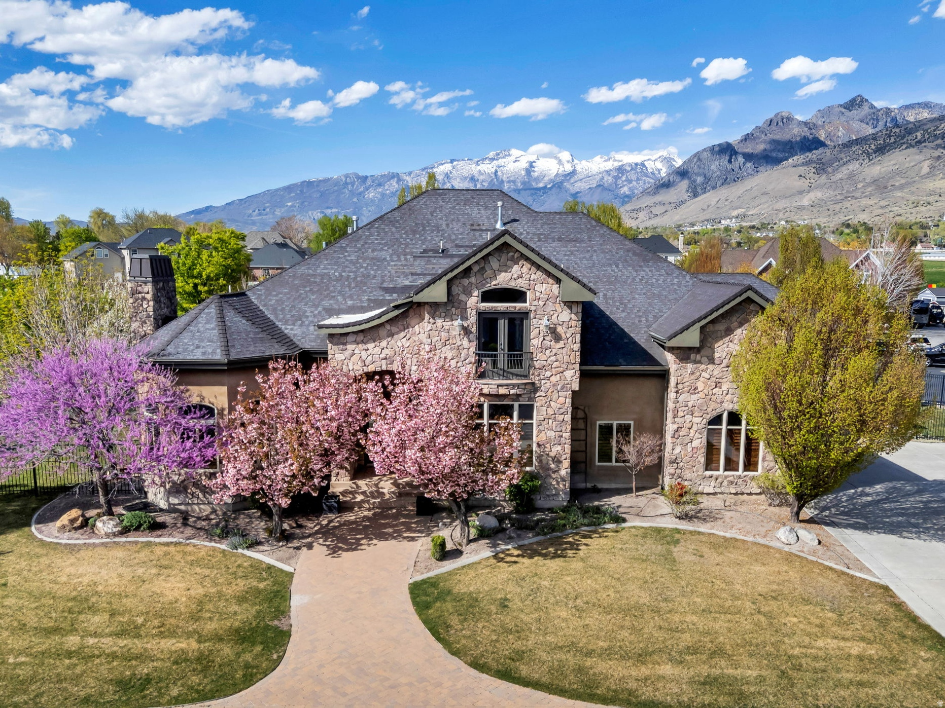 Welcome to one of the most captivating estate properties in Pleasant Grove, where timeless design meets privacy, space, and unforgettable character. Situated on a rare half-acre at the end of a quiet street and a cul-de-sac, this 7,265 sq ft home offers 5 bedrooms, 4 bathrooms, and a fully equipped basement apartment with a separate entrance, perfect for rental income or multigenerational living.  The sellers are currently installing a brand new roof, providing a significant upgrade to the property. Surrounded by open fields and located near the Timpanogos Temple, the setting is both peaceful and picturesque. Inside, you'll find a chef's kitchen, executive office, home theater, plantation shutters, and unique architectural features, including a hidden room, secret passageway, and concealed butler's pantry that add charm and intrigue.  The outdoor space is just as impressive, featuring a private backyard retreat with a waterfall, hot tub, trampoline, garden boxes, fruit trees, and mature landscaping. Enjoy multiple outdoor living areas, including a balcony, expansive deck, and walkout basement patio.  With an RV garage, four total garage spaces, and parking for approximately 10 vehicles in the circular driveway, this property offers both luxury and functionality in one of the quietest and most desirable neighborhoods in the area. Come see!