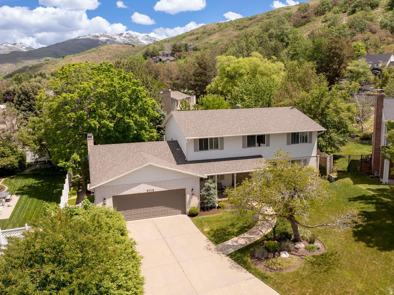 This beautiful 6-bedroom, 5 bathroom home, has a spacious 2-car garage and includes a finished basement with separate entrance providing potential for a future mother-in-law apartment. Hardwood floors, plantation shutters, skylights, French glass doors, and abundant natural light create a warm and inviting feel throughout. The oversized primary suite features a private deck, jetted tub, dual sinks, and large shower with steam option.  Designed for comfort and entertaining, the home includes 3 furnaces, 2 AC units, central vacuum, and generous storage throughout, including cold storage with built-in shelving, a large laundry room, and multiple refrigerators/freezers. The kitchen is equipped with a gas cooktop, double ovens and a large dining area.  The fully landscaped and fenced backyard is truly summer-ready, featuring mature trees, a covered tile patio, adjacent deck, large shed, and a sand area perfect for a firepit or sandbox. Ideally located near Bountiful Ridge Golf Course and Mueller Park Canyon with quick access to hiking and biking trails. This lovely home won't last long! Buyer to verify any and all provided information.