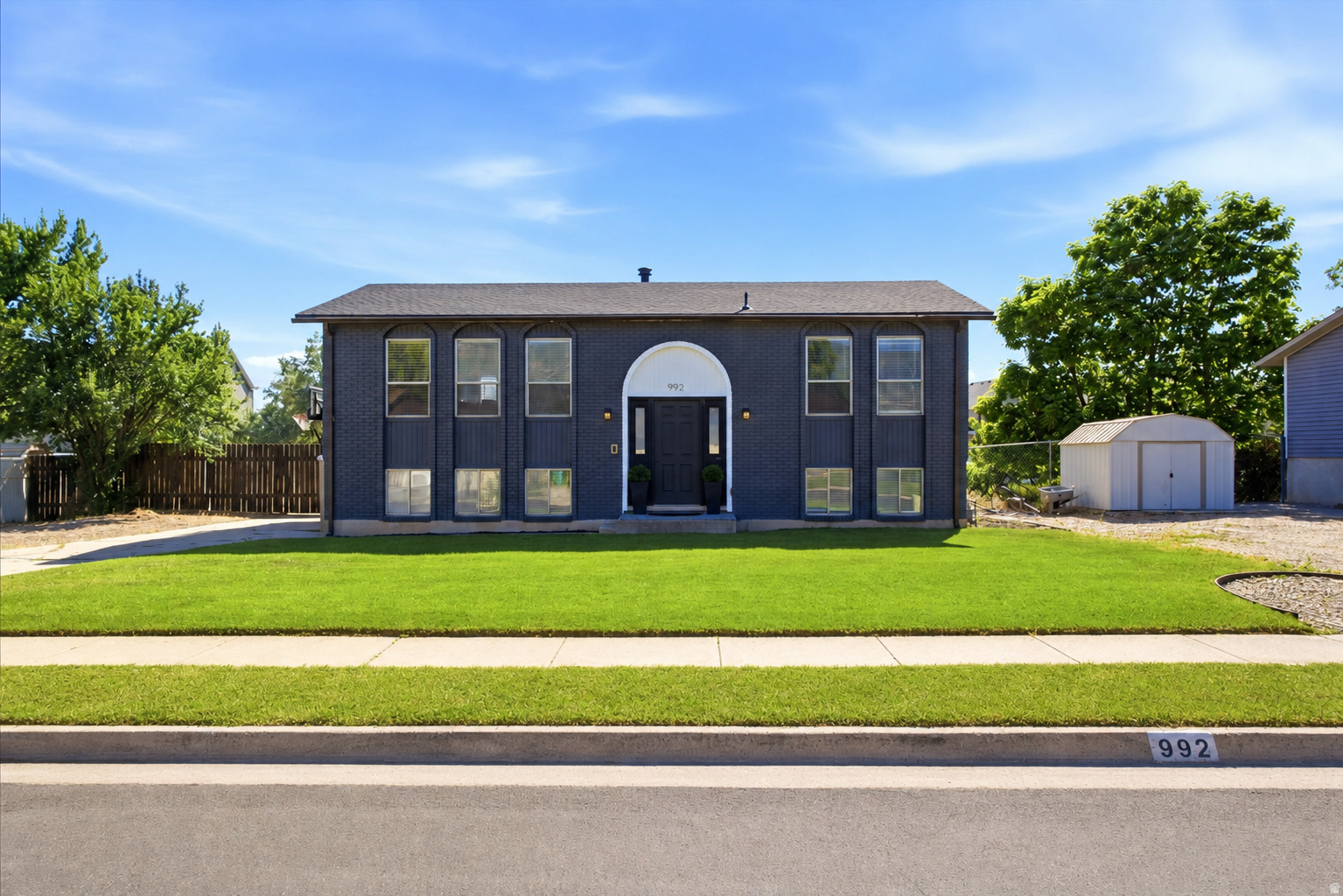 OPEN HOUSE THIS SATURDAY 06/22/2026 9:00 AM - 11:30 AM. Enjoy this beautifully updated 2,000-square-foot home in Layton featuring a brand-new roof and central A/C for year-round comfort. Offering 4 bedrooms and 2.75 bathrooms, this home combines modern updates with functional living spaces. The remodeled kitchen showcases gorgeous quartz countertops, stainless steel appliances, and easy access to a new Trex deck with stylish metal railings-perfect for entertaining or enjoying outdoor meals. Updated flooring runs throughout the main level, while the kitchen opens seamlessly into a spacious family room with stunning mountain views. The primary suite features a private full bathroom accented by a charming sliding barn door. Downstairs, you'll find a large second family room, two additional bedrooms, and an updated 3/4 bathroom complete with a granite countertop. The walkout basement leads to a fully fenced 0.23-acre backyard offering plenty of room to enjoy the outdoors. The yard includes a vegetable garden, storage shed, and trampoline, creating the perfect space for relaxation, gardening, and play.