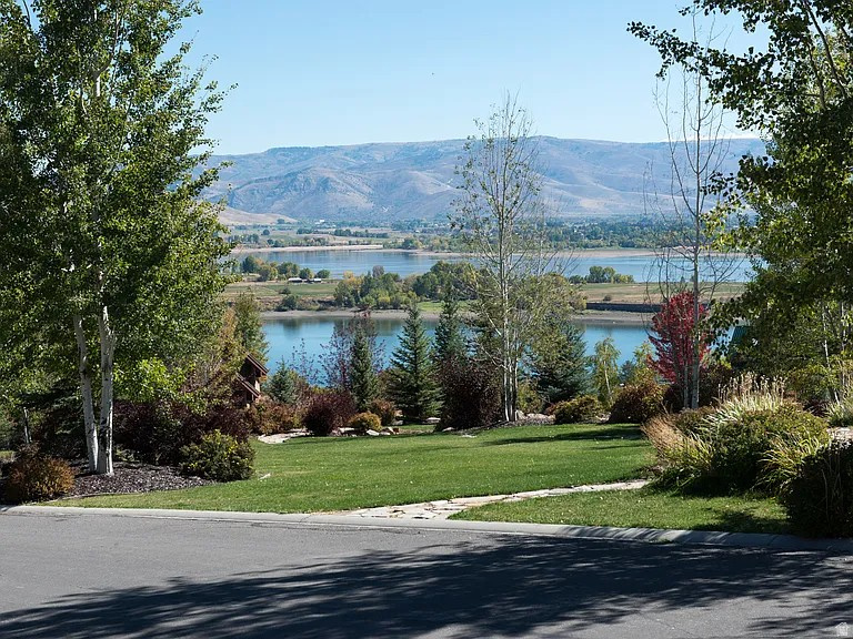 The Last Unobstructed Lake View Lot in Crimson Ridge. Wake up every morning to Pineview Reservoir shimmering below, framed by the Monte Cristo range and the full sweep of Ogden Valley. This is not a "peek-a-boo" view. This is a panoramic, protected, jaw-dropping vista that greets you the moment you step outside, and it's yours to build around. This south-facing lot sits in The Reserve at Crimson Ridge, one of the Ogden Valley's most established luxury gated communities, perched on the western hillside above the reservoir. It is the last remaining homesite in the community with a direct, unobstructed lake and mountain view. Across the street is a protected view corridor, meaning no future construction will ever compromise what you see from this lot. That kind of guarantee is nearly impossible to find in this market. The lot is level, buildable, and thoughtfully oriented. A south-facing home here captures natural light all day long, and the lot's position means you won't have car headlights sweeping through your windows at night. Mature scrub oaks surround the property, giving you seclusion and a sense of being tucked into the mountain while still commanding those wide-open views. Privacy and panorama, together.   Crimson Ridge is a fully improved community on culinary water (Pineview West Water Co.) and a community sewer system. Homesites are approximately one acre. Residents share a clubhouse with pool, hot tub, fitness center, gathering areas, and kayak access. Walking trails lead up toward the Skyline trail above. It's a short walk from this lot to the clubhouse and pool, making it easy to enjoy community amenities daily.   Location is one of Crimson Ridge's strongest advantages. Situated centrally between Snowbasin Resort and Powder Mountain, you're minutes from world-class skiing in either direction. A scenic ten-minute drive through Ogden Canyon puts you in downtown Ogden, and Salt Lake City is under an hour away. Nordic Valley rounds out three ski resorts all within easy reach. In the warmer months, Pineview Reservoir is your backyard for boating, paddleboarding, fishing, and swimming. Hundreds of miles of hiking and mountain biking trails are right outside the gate.   This lot has been held by the neighboring property owners for years. It is now available for the first time, and the seller is willing to offer financing with 25% down on negotiated terms for a qualified buyer. That's a rare opportunity on a lot like this.   If you've been waiting for the right piece of ground to build your forever home in the Ogden Valley, this is it. Unobstructed views. Gated privacy. Four-season recreation at your doorstep. There is nothing else like it left in Crimson Ridge. PROPERTY HIGHLIGHTS   - Last unobstructed lake, mountain, and valley view lot in Crimson Ridge - South-facing, level homesite ideal for custom home construction - Protected view corridor across the street ensures views in perpetuity -Mature oak trees provide natural privacy and seclusion - Lot orientation prevents car headlight intrusion - Fully improved lot: culinary water, community sewer, utilities in place -Gated community with clubhouse, pool, and trails -Walking distance to community clubhouse and pool - Minutes from Snowbasin Resort and Powder Mountain ski areas - 10-minute drive to downtown Ogden via Ogden Canyon - Under 1 hour to Salt Lake City International Airport - Seller financing available: 25% down on negotiated terms for qualified buyer
