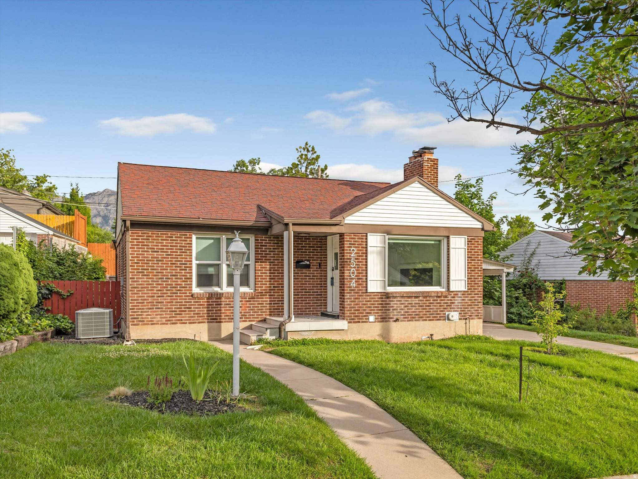 Located in the highly sought-after Country Club Heights neighborhood of Sugar House, this classic red brick cottage perfectly blends timeless charm with modern updates in one of Salt Lake City's most walkable and desirable communities. Ideally situated near top-rated schools, beautiful Sugar House Park, boutique shopping and local restaurants.  It is just minutes from the University of Utah, downtown Salt Lake City, Salt Lake City International Airport, and world-class skiing in Park City and the Cottonwood Canyons, this location offers the very best of Utah living. This darling home features 1,925 square feet, four bedrooms and two beautifully updated bathrooms. The ideal floor plan includes an open-concept kitchen, a spacious main living room, and a versatile rec room, exercise room, home office, or flex space on the main floor. Thoughtfully updated throughout with toungue and groove laminate flooring, fresh designer paint, stylish lighting, and newer windows, the home feels both inviting and move-in ready. The warm and welcoming living room showcases a large picture window that fills the space with natural light, along with a cozy fireplace featuring a custom mantle and tiled hearth. The gourmet kitchen is beautifully appointed with stainless steel appliances, a gas range, custom white cabinetry, quartz countertops, and a sleek subway tile backsplash. Both bathrooms have been tastefully remodeled with new tile, updated fixtures, modern surrounds, and designer hardware. The finished basement provides additional flexible living space ideal for guests, hobbies, a media room, or home gym. Outside, the private backyard retreat features a deck off the main floor, terraced garden beds, automatic sprinklers, mature landscaping, a storage shed, and a lush front lawn. A large driveway and carport provide ample parking and storage for all your outdoor gear. Don't miss this opportunity to own a beautifully updated home in one of Sugar House's premier locations.