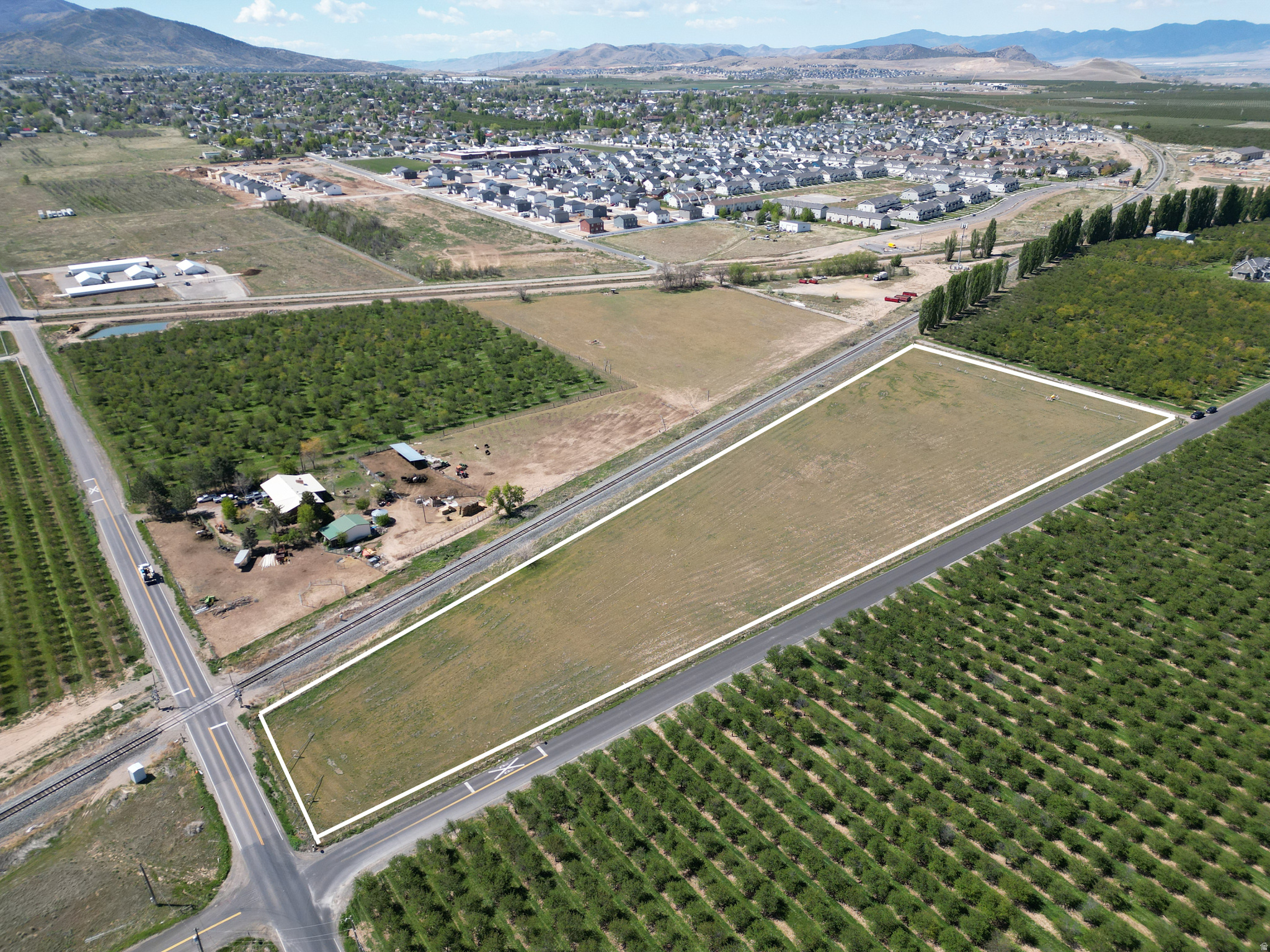 Spanning 5.76 acres, this residential agricultural property provides a prime opportunity for those in search of productive land surrounded by natural beauty. The parcel comes with 11.2 water shares and is outfitted with pressurized irrigation, making it ideal for farming operations or maintaining livestock. Fully enclosed and presently used for cattle grazing, the property is both efficient and adaptable to a variety of uses. Enjoy sweeping mountain and valley views, all while being situated next to established orchards and a newer residential development-offering a unique combination of quiet country living and convenient proximity to growth.