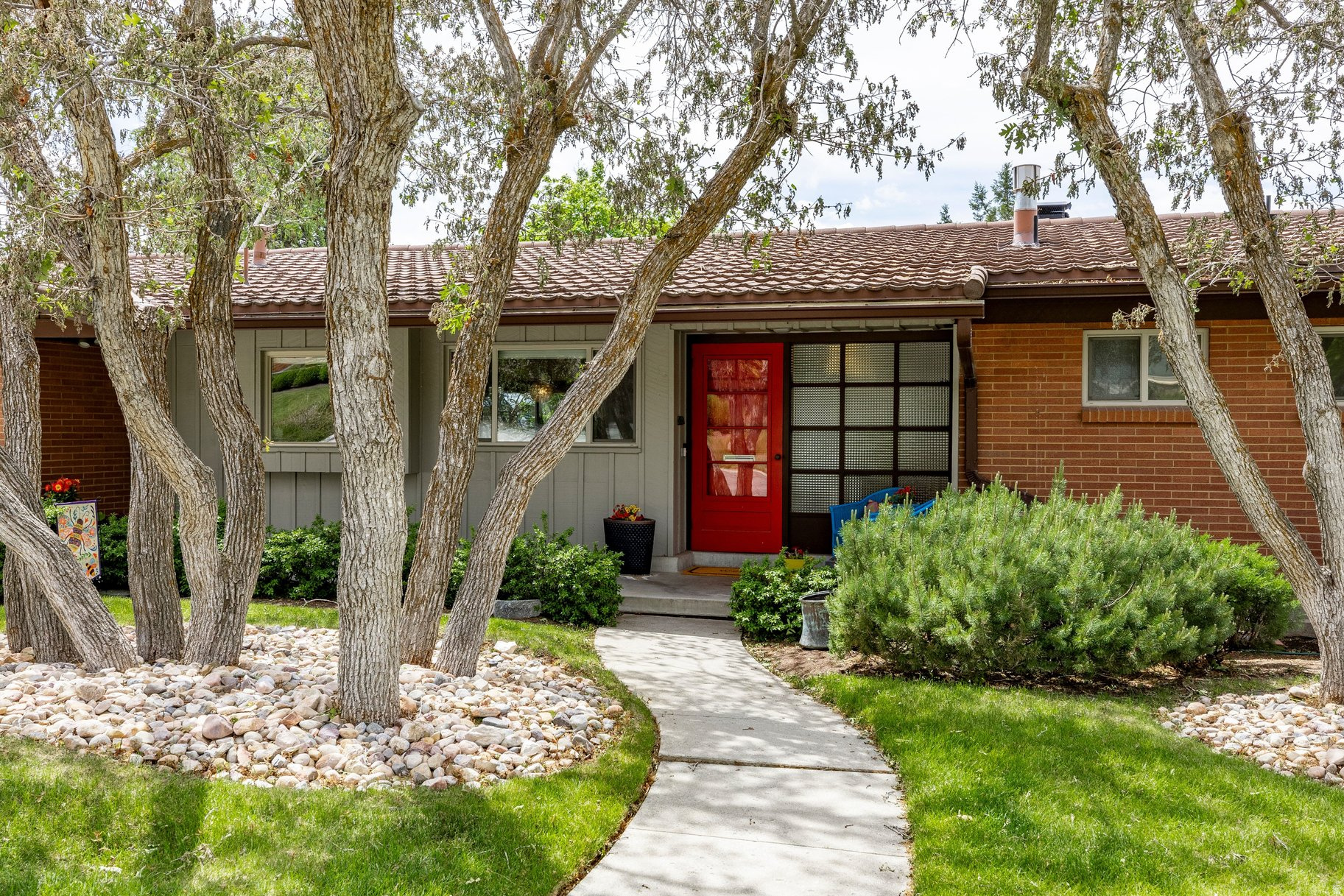 Situated on a quiet street in the highly desirable St. Mary's neighborhood, this beautifully updated rambler blends original charm with a contemporary open floor plan and thoughtful design details throughout. A terrazzo entry welcomes you inside, where expansive windows on all sides fill the home with natural light and offer west-facing sunset views year-round. The kitchen features a large island with bar seating and a secondary prep sink, a gas range with hood, stainless steel appliances, ample cabinetry, a built-in desk, and a large window above the main sink. The layout makes it easy to cook, gather, and stay connected to the rest of the main level. From here, enjoy seamless access to the covered back deck and patio, west-facing and ideal for outdoor dining, barbecuing, and relaxation. The main living area centers around a gas-insert fireplace with walnut surround, flanked by built-in shelves and cabinetry with integrated lighting, creating a warm and inviting gathering space, and beautiful west-facing views. The primary suite comfortably fits a king bed and seating area, with windows on multiple sides for sunrise and sunset views. The suite opens to a spacious walk-in closet with a built-in island and cabinetry drawers, and a fully updated bath with designer finishes, a walk-in shower with bench and niches, and a private water closet. Updated lighting and designer touches upstairs reflect a cohesive, professionally considered aesthetic.The daylight basement adds significant living space, with a large family room and walkout access to the backyard, generous storage throughout, and a laundry room that doubles as an arts and crafts workspace with built-in shelving and galvanized countertops. Additional features include real hardwood flooring, a water softener, Google Fiber, and updated lighting throughout. The backyard is flat and fully usable, with mature landscaping, a lush lawn, mountain views, a galvanized garden box, and plenty of room for playing, pets and entertaining. Minutes from the University of Utah, Primary Children's Hospital, Hogle Zoo, Emigration Canyon, and downtown Salt Lake City, with easy freeway access and Foothill Village shopping and dining nearby.