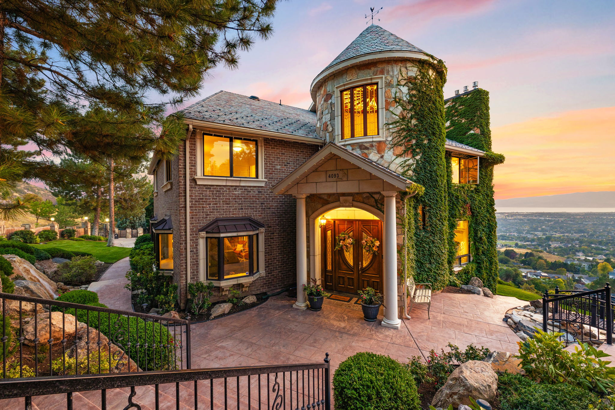 In a world of gray-and-beige interiors, laminate flooring, and builder-grade finishes, 4093 N Imperial Way stands apart. Set on 1.7 acres with sweeping views of Utah Lake, the valley, and the surrounding mountains, this French chateauinspired estate offers a level of character, craftsmanship, and presence that is nearly impossible to replicate today.  Originally built as an entertaining showcase, the home was later extensively rebuilt and improved with a long list of structural and cosmetic upgrades, including a 50-year DaVinci Slate roof, updated windows and doors, a redone stone-and-brick exterior, extensive decking, upgraded mechanical systems, refreshed landscaping, and more. The exterior features real quartz stone, artisan brick, cast concrete trim, gated access, mature landscaping, water features, and a private resort-style backyard complete with an 18' x 40' pool, hot tub, diving board, slide, pool house, basketball court, playground, and open lawn space.  Inside, the home feels grand, warm, and unapologetically custom. The entry turret features a dramatic circular staircase and stained-glass ceiling, while heated marble floors, black granite accents, custom wrought iron, coffered ceilings, intricate millwork, stained glass details, chandeliers, and multiple fireplaces carry the home's old-world elegance throughout. The kitchen was built for hosting, with cherry cabinetry, granite countertops, dual dishwashers, double ovens, a large island, and a fireplace-connected living space that opens toward panoramic views.  The layout offers both formal and casual gathering spaces, including a banquet-sized dining room, music room or office, large view-facing living areas, a 30' x 22' theater room, whole-home audio, a basement kitchenette, multiple laundry areas, and generous bedroom suites. Expansive decks, walkout spaces, and multiple separate living areas make the home exceptionally well-suited for entertaining, multi-generational living, or simply enjoying one of Provo's most unique private settings.  The lot itself is a major part of the offering. With approximately 350 feet of street frontage, rare usable acreage, and a north portion that was historically separate and still has its own utility service, the property may offer future subdivision or build potential. Buyer to verify all development possibilities with Provo City.  Located near Provo Canyon, Little Rock Canyon, hiking trails, Riverwoods shopping and dining, Sundance Resort access, and major transportation corridors, this is one of Provo's most distinctive luxury estates: bold, timeless, and completely unlike anything else on the market.  Square footage figures are provided as a courtesy estimate only. Buyer is advised to obtain an independent measurement and verify all property details.
