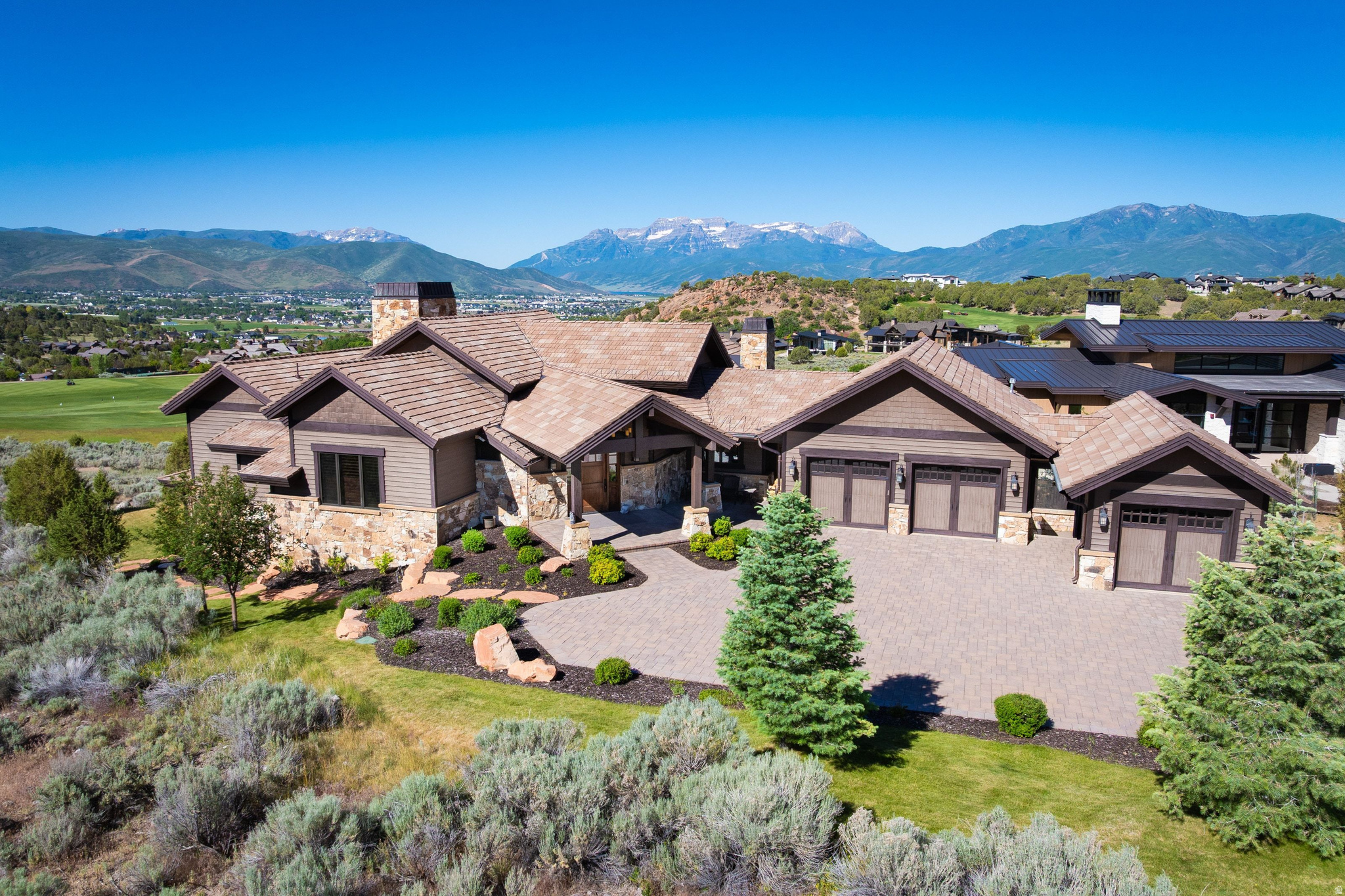 Nestled within the prestigious gates of Red Ledges, 2910 E Brown Duck Mountain Circle is an exceptional mountain traditional estate designed by renowned architect Kevin Price. Perfectly situated to capture sweeping golf course views while maintaining remarkable privacy, this 6,361-square-foot residence embodies timeless mountain elegance and refined craftsmanship. Thoughtfully designed for gathering and entertaining, the home features six spacious bedrooms and six bathrooms, offering ample room for family and guests. Rich natural materials, warm architectural details, and expansive windows create an inviting atmosphere that seamlessly connects the interior to the surrounding landscape. The open-concept great room serves as the heart of the home, flowing effortlessly into beautifully appointed living and dining spaces. Multiple outdoor living areas provide the perfect setting to enjoy serene mornings overlooking the fairways and unforgettable evenings beneath the Wasatch Mountain skies. Designed with recreation and hospitality in mind, the home includes a dedicated home theater and an oversized bunk room, creating ideal spaces for hosting family, grandchildren, and guests year-round. Whether serving as a primary residence or mountain retreat, every detail has been carefully curated to support a luxurious yet comfortable lifestyle. A Full Golf Membership is available with the purchase of the home, providing access to Red Ledges' award-winning Jack Nicklaus Signature Golf Course, state-of-the-art practice facilities, clubhouse dining, tennis and pickleball courts, fitness and wellness amenities, swimming pools, equestrian facilities, and an active year-round social calendar. Ideally located just minutes from Deer Valley East Village, Jordanelle Reservoir, and the endless outdoor recreation of the Heber Valley, this remarkable Kevin Price-designed residence offers a rare opportunity to own one of Red Ledges' premier golf course properties.