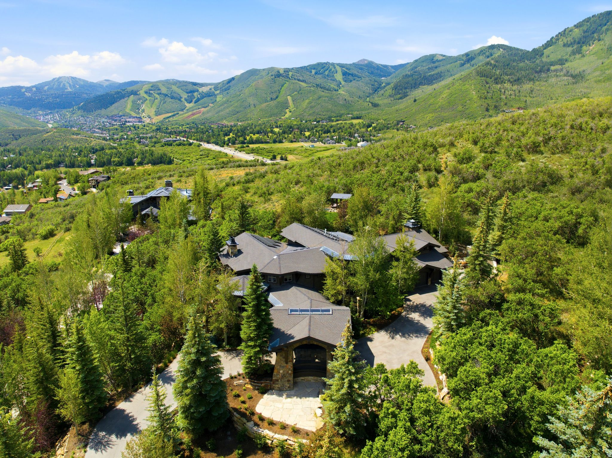 35 Sandstone Cove Court is a rare in-town estate offering 4.16 private acres, exceptional amenities, and sweeping views of Park City's ski resorts and surrounding mountains. Originally designed by acclaimed architect Michael Upwall and extensively remodeled by the Jaffa Group in 2016, the residence blends timeless mountain architecture with sophisticated contemporary finishes across 10,215 square feet. The home features seven bedrooms, ten bathrooms, multiple gathering spaces, and a thoughtful floor plan designed for both everyday living and large-scale entertaining. The dramatic great room showcases soaring timber-beamed ceilings, walls of glass, and a floor-to-ceiling Montana Moss Rock fireplace. A beautifully remodeled chef's kitchen offers Taj Mahal quartzite countertops, dual islands, Wolf and Sub-Zero appliances, dual Bosch dishwashers, a built-in espresso machine, and an adjoining butler's pantry.  The main-level primary suite is a private retreat with a stone fireplace, spa-inspired bath, steam shower, soaking tub, and custom walk-in closet. Additional amenities include a private office, theater, loft billiards room, family rooms, climate-controlled 960-bottle wine cellar, fitness room, wellness suite with cedar sauna and steam shower, and multiple guest suites.  Outdoor living rivals a private resort with a heated pool, elevated spa with cascading water feature, expansive heated stone patios, pavilion, and beautifully landscaped grounds offering exceptional privacy. Additional features include radiant in-floor heating, air conditioning, heated driveway and patios, whole-home audio, smart home technology, and a heated four-bay garage complete with boot dryers and dog wash.  Just minutes from Deer Valley, Park City Mountain, Historic Main Street, golf, trails, and world-class dining, this is a rare opportunity to own one of Park City's premier legacy estates.