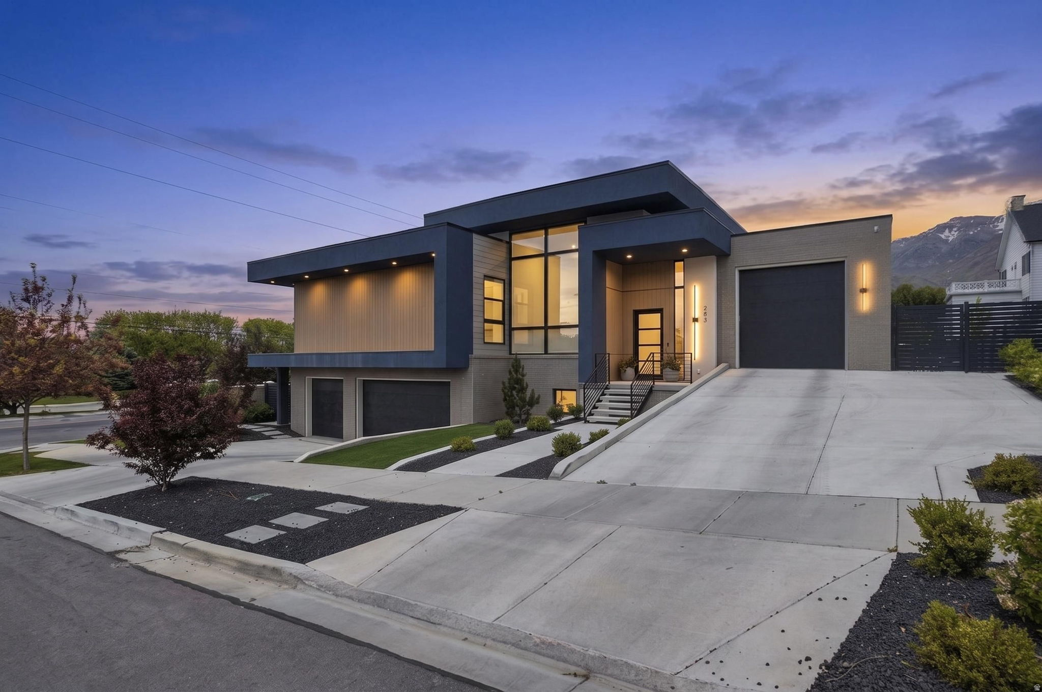 Designed for unforgettable entertaining, this ultra modern Northeast Provo estate in The Preserve blends luxury, lifestyle, and mountain views in one exceptional property. From the moment you walk in, the home feels built for gathering, with expansive open living spaces, dramatic 14 foot ceilings, floor to ceiling glass doors, and seamless indoor outdoor flow overlooking Mount Timpanogos.  The heart of the home is the gourmet kitchen, featuring a massive waterfall island, hidden pantry, catering kitchen, four total ovens, two oversized stainless steel fridge and freezer units, gas range, pebble ice maker, and high end appliances. The kitchen opens to a grand great room with a gas fireplace, custom accent wall, and walls of glass that lead directly to the 500 square foot deck, heated in ground pool, outdoor putting green, and fully fenced xeriscape yard. Whether you are hosting summer pool parties, holiday dinners, game nights, or quiet evenings with mountain views, this home was designed to make every gathering feel effortless.  The main floor primary suite is a private retreat with direct deck access, Timpanogos views, an electric fireplace, freestanding tub, oversized walk in shower with waterfall head, body jets, sprayer, French drains, and an incredible closet suite with built in cabinetry, laundry, linen storage, sink, PLUS a private office or nursery. A second main floor bedroom with built ins and a nearby full bathroom adds flexibility for guests or multigenerational living.  The lower level continues the entertaining experience with four additional bedrooms, three with ensuite bathrooms, a spacious great room, a 2nd laundry room, and high end modern finishes throughout. The sub basement offers a full bathroom, cold storage, a 16 by 32 flex space currently used as a baseball and golf simulator with rubber flooring, soundproof walls, and mini split, plus a separate gaming and lounge area.  Additional features include an oversized four car garage with black epoxy floors and custom cabinetry, two EV chargers in the lower garage, upper garage prewired for an additional EV charger, smart MyQ garage openers, two tankless water heaters, water softener, permanent exterior lights by Everlights, newer landscaping and driveways, rooftop deck, heated pool with automatic cover, and incredible outdoor spaces designed for low maintenance living.  Perfectly located just minutes from BYU, Riverside Country Club, and Sundance, this one of a kind home offers the best of Northeast Provo living with the space, amenities, and design to entertain beautifully year round.