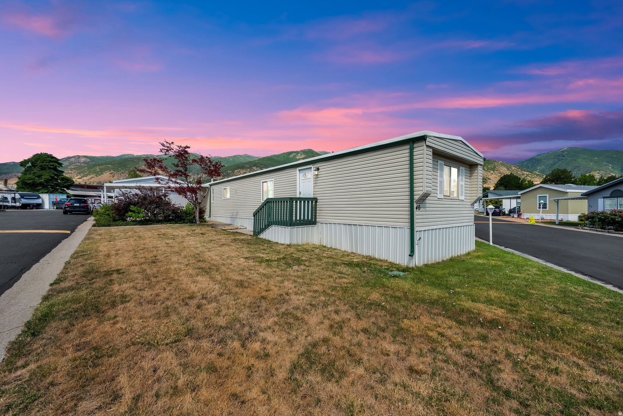 Affordable homeownership opportunity in highly desirable Fruit Heights! Located in the well-maintained Apple Acres Community, this 2-bedroom, 2-bath home offers a functional floor plan, abundant natural light, and comfortable living spaces throughout. Enjoy the fully fenced yard, covered patio, covered carport, and beautiful mountain views. The thoughtful layout provides privacy and flexibility while offering a warm and inviting atmosphere to call home. Conveniently located near shopping, restaurants, parks, schools, Highway 89, I-15, Farmington Station, and outdoor recreation. This is an excellent opportunity for buyers seeking an affordable path to homeownership in one of Davis County's most sought-after communities. Monthly lot rent fee approximately $975 plus water, sewer, trash, and shared community fee (not an HOA fee). Total monthly fees, including lot rent and community fee, are approximately $1,070 per month. Buyer to verify all fees. Community application and approval required. Pat is the Park Manager.