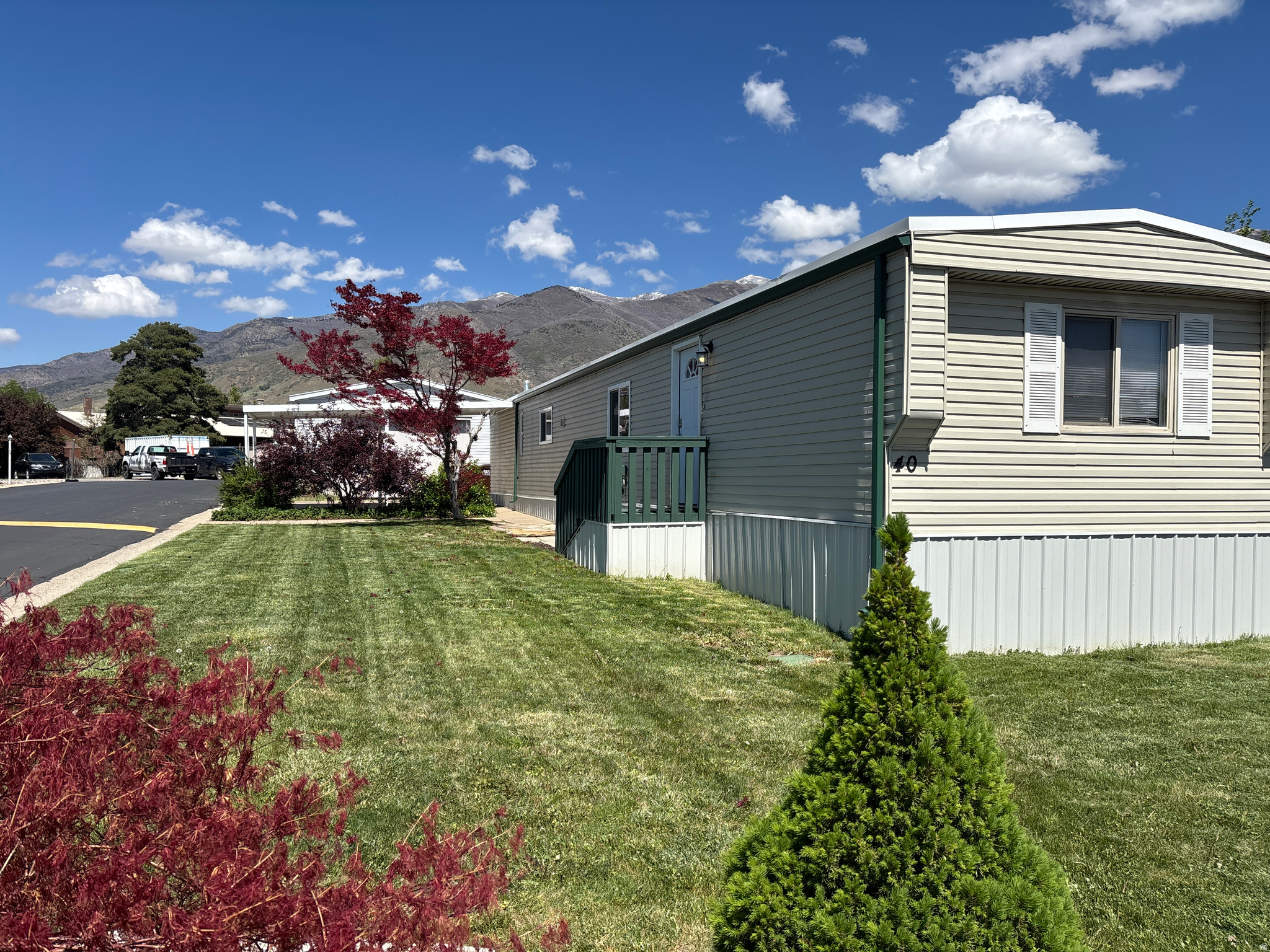 Affordable homeownership opportunity in highly desirable Fruit Heights! Located in the well-maintained Apple Acres Community, this 2-bedroom, 2-bath home offers a functional floor plan, abundant natural light, and comfortable living spaces throughout. Enjoy the fully fenced yard, covered patio, covered carport, and beautiful mountain views. The thoughtful layout provides privacy and flexibility while offering a warm and inviting atmosphere to call home. Conveniently located near shopping, restaurants, parks, schools, Highway 89, I-15, Farmington Station, and outdoor recreation. This is an excellent opportunity for buyers seeking an affordable path to homeownership in one of Davis County's most sought-after communities. Monthly lot rent fee approximately $975 plus water, sewer, trash, and shared community fee (not an HOA fee). Total monthly fees, including lot rent and community fee, are approximately $1,070 per month. Buyer to verify all fees. Community application and approval required. Pat is the Park Manager.
