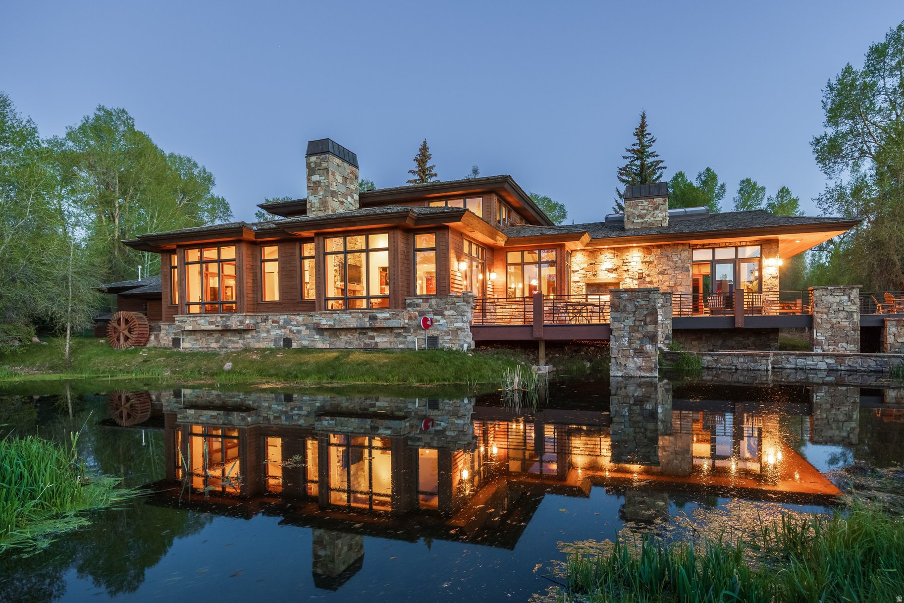 Accessible via a private gated road, this extraordinary Weber River estate spans more than 20 acres with Weber River frontage and multiple ponds, offering a rare blend of privacy, natural beauty, abundant wildlife, and convenience. A rare riverfront sanctuary, this Estate is more than a home, it's an immersive experience in nature and design. At its heart, this property is an approximately 6,000-square-foot mountain contemporary residence designed by Otto Walker Architects for both entertaining and everyday living, featuring an open-concept great room with exposed wood beams, floor to ceiling windows and vaulted transom windows, semi formal dining area, cozy den, game room, two stone accented wood burning fireplaces, and a gourmet kitchen with Wolf and Sub-Zero appliances. The home includes three ensuite guest bedrooms and a private primary suite with its own deck and office. Connected to city water and sewer; additional conveniences include available water shares. A barn with stalls and fenced pastureland further enhances the property, all set within a landscape rich with wildlife. The property captures an unmatched connection to the outdoors with world-class fly fishing, riverfront living, and sweeping mountain and valley views, making it ideal as a private retreat, equestrian estate, or generational legacy property. Additional 20 Acre Parcel Available.