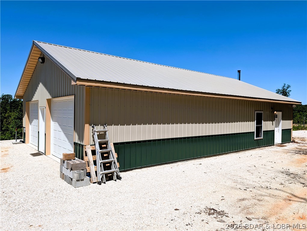 45.4  ACRES & "MANCAVE" Newer 32 ft x 50 ft  metal building built on a full slab concrete floor. 704 sq ft of partially finished living space studded walls, 1 bedroom & 1 full bath also living room, dining, kitchen features industrial deep well double kitchen sink, SS refrigerator, Janska 36" commercial freestanding gas over electric stove, New  washer and dryer & water softener. Lots of windows to enjoy the wildlife and space surrounds by 45.4 wooded  surveyed acreage with lots of road frontage. You will find a 2 car oversize 32x28 attached garage. features 10 ft door and a 11 ft door with 2 openers.   The interior is just waiting for your finishing touches. Walls and ceiling have sprayed insulation.  Heating the home is easy with the Englander Blue Ridge 500 top of the line wood stove.   Mini split just waiting to be hooked up. CO-MO  fiber internet. Other features framed 3 ft doors easy level access, 2x6 walls with a  9 ft ceiling height. Drilled well and septic/lagoon.  Security  light and camera.  Montana Rd is a dead end road. The land is perfect for a recreational retreat features mixed terrain for making trails in the outdoors. Near a Lake Access at the 10 mm Gravois Mills.