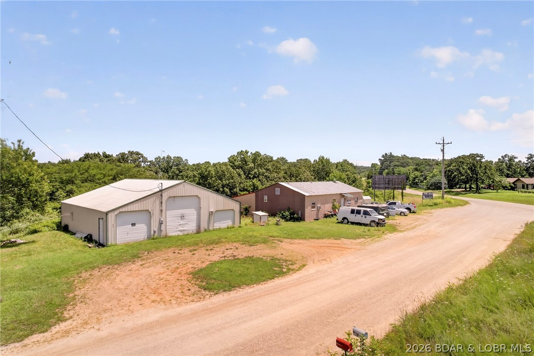 Commercial opportunity with exceptional Highway 42 frontage and visibility. Situated on 2 level acres with approximately 345 feet of road frontage, this versatile shop building and house offers excellent exposure and easy access for a variety of business ventures. Whether you're looking for a contractor's shop, warehouse, equipment storage, automotive use, agricultural operation, or future commercial investment, this property provides the flexibility to fit your needs. A shared well is already in place, and the spacious lot offers plenty of room for parking, equipment, or future expansion. Billboard on property.  Conveniently located just minutes from Osage Beach and within easy driving distance of the Lake of the Ozarks, this property is ready for your next business opportunity.