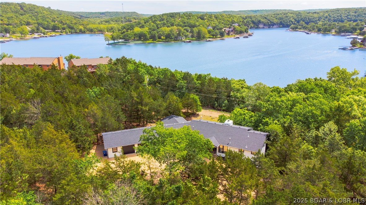 BACK ON MARKET AT NO FAULT OF SELLER.  This 4000+ square foot home was built with luxury in mind.  New roof, ready for a new family, in the best location!   The 4.5 acres of privacy within 2 minutes of Lake Valley Golf Course and about 4 minutes to Kinderhook Golf Course makes this location a dream for every golfer.  Only minutes from the city center of Camdenton boasting  a beautiful lake view and a coveted location that highlights an area of upscale homes.   From the minute you walk in the door the large windows cast such a beautiful natural light in the great room and kitchen.  An office turned music room is perfect for a Baby Grande Piano, with a new sunroom features a cozy nook right off the kitchen.  Additionally the breezeway attaching the garage to the house has been transformed into the perfect place for your outdoor kitchen and covered outdoor dining area.  The kitchen being something dreams are made of with 2 full size refrigerators and the massive center island that is the heart of this home.  This is the perfect place to park a boat or build another garage for your RV and boat storage.  A golf cart ride to Lake Valley Country Club, and a community dock down the hill.