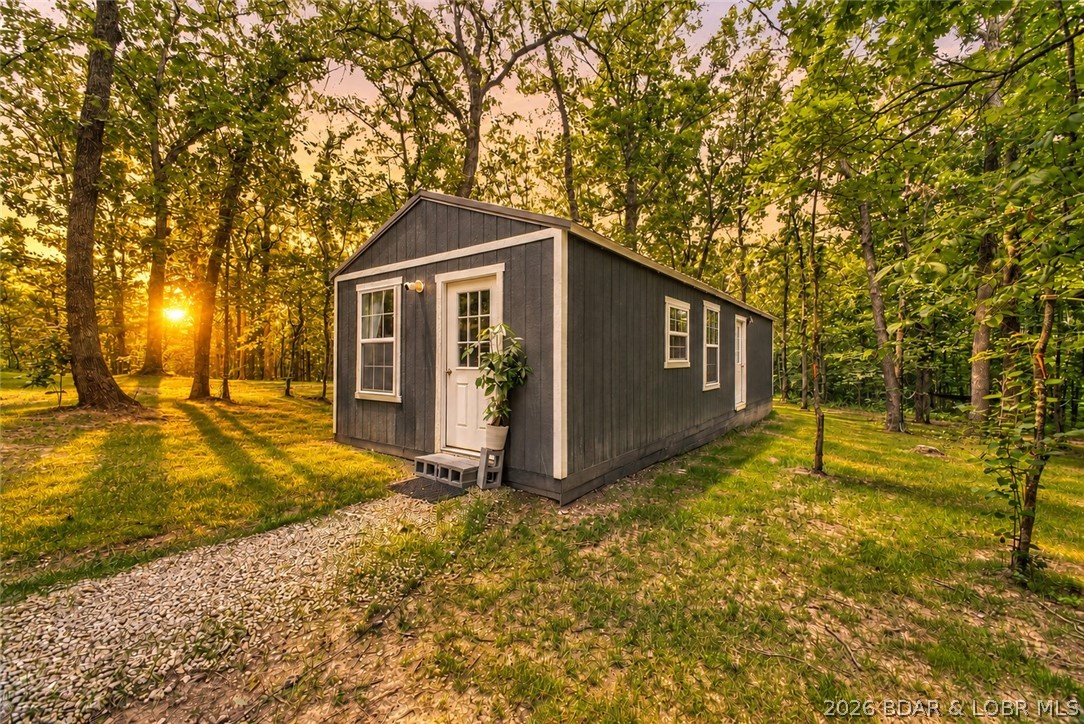 Private 5.82-Acre Homestead Retreat! Tucked away just off blacktop, this one-of-a-kind property is ready for your next adventure. Featuring a beautifully crafted home with quality finishes, custom cabinets, jetted tub, gas range, plus a new well, septic, 2 mini ac splits, 2 RV pads with hookups, 2 steel storage containers, greenhouse, garden areas, STYLISH She Shed with heat/AC, bird coop, firepit, young magnolia, peach and elderberry trees, small shop/tool shed, and room to grow. Whether you're looking for a full-time residence, weekend getaway, homestead, or investment opportunity, this turnkey property offers privacy, functionality, and endless possibilities. All just minutes from the Lake of the Ozarks, Coffman Beach boat ramp, shopping & restaurants.