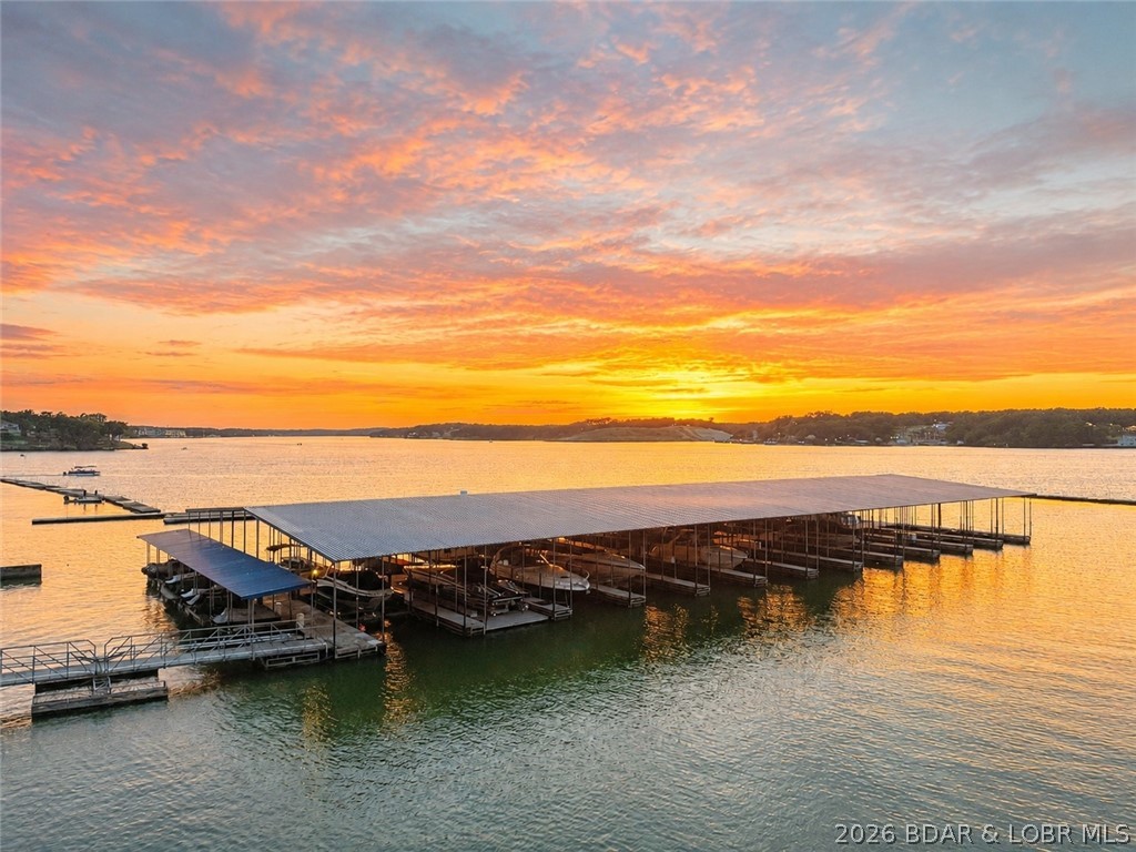 Luxury lakefront condo in the highly sought-after Lands End Condominiums in the heart of Osage Beach!  Turn-key, fully furnished 4-bedroom, 5-bath condo offers 3,410 square feet of living space and breathtaking sunset views overlooking the lake's famous 7 mile main channel at 19-mile marker.
The spacious floor plan features two lakeside primary suites with private deck access, three bedrooms with king beds, a large living room, family room, two gas fireplaces, two jetted tubs, and a full-size laundry room.  Extensive 2024 updates include new stainless-steel appliances, commercial-grade ice maker, new flooring and carpet, updated countertops, and a new HVAC system.
Enjoy two private lakeside decks, each with storage rooms and owner lockout closets. True no-step access provides easy entry from parking to the condo and ramp all the way to a 16x48 boat slip and two PWC slip. Lands End amenities include a zero-entry pool, lazy river, splash pool, clubhouse, fitness center, playground, and beautifully maintained grounds. Vacation rentals are permitted, making this an exceptional personal retreat or investment opportunity in one of Lake of the Ozarks' premier communities.  Owner/Broker