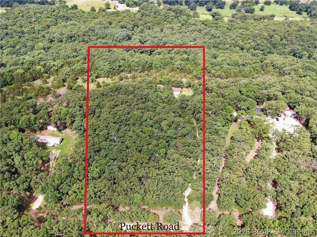Discover the perfect blend of privacy, convenience, and opportunity with this beautiful 5-acre tract located at 27 Puckett Road in Eldon, Missouri. Nestled on a quiet gravel road in the countryside, this property offers a fantastic setting for your dream home, weekend getaway, hunting retreat, or future homestead.   The land is mostly wooded, providing excellent privacy and abundant wildlife, while several open areas offer ideal locations for building, gardening, recreation, or camping. Improvements are already in place, including a private well, lagoon sewer system, electricity, and a detached 2-car garage—saving you time and expense as you bring your vision to life.  Whether you're looking for a peaceful place to build, a recreational property, or a secluded escape with utilities already established, this acreage checks all the boxes. Enjoy the tranquility of country living while remaining just a short drive from Eldon, Lake of the Ozarks, and all the amenities the area has to offer.