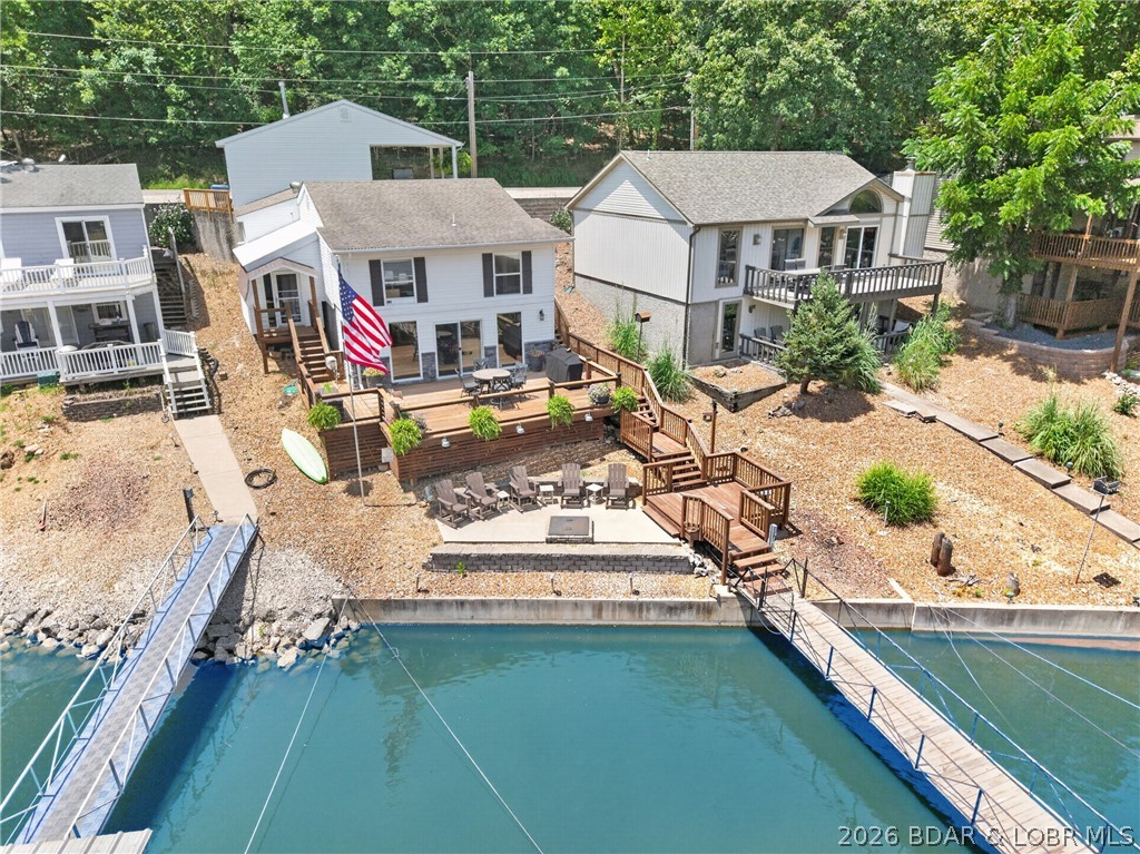 Discover the perfect blend of location, lifestyle, and investment potential with this beautifully updated lakefront home in the heart of Osage Beach. Ideally situated off KK by land and at the 22mm by water, you’re just minutes from championship golf, waterfront dining, shopping, entertainment, and the hospital. Offering approximately 2,100 square feet, this 4-bedroom (4th non-conforming), 2.5-bath home has been thoughtfully updated with luxury vinyl plank flooring, modern lighting, custom accent walls, updated bathrooms, fresh interior paint, and a stunning kitchen featuring granite countertops, newer cabinetry, tile backsplash, and stainless-steel appliances. The inviting living room is anchored by a gorgeous stone fireplace with an electric insert. The traditional floor plan places all bedrooms upstairs, while the main level offers an open kitchen, dining, and living area with laundry and a half bath. Outside, enjoy a gentle lakeside lot with a spacious deck, firepit, finished storage shed, and a private two-well dock. Sold mostly furnished and complete with a detached 2-car garage plus attached carport. Short-term rentals are permitted, this would make an excellent investment!