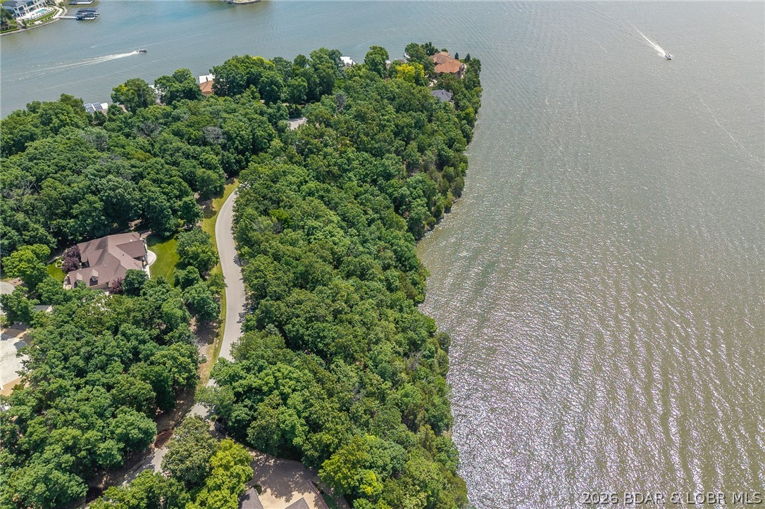 This premier Lakefront lot at The Villages at Shawnee Bend delivers the ultimate Lake of the Ozarks lifestyle with direct water access and breathtaking shoreline views. Arrive through the iconic grand waterfall entrance and enjoy a community known for its upscale amenities and attention to detail. Residents have access to a community marina, elegant clubhouse, multiple pools, championship tennis courts, and pickleball facilities, along with park and playground areas. With paved roads and underground utilities already in place, this lot is perfectly suited for a custom lakefront home with dock potential. A rare opportunity to own lakefront property in one of the lake’s most distinctive communities.