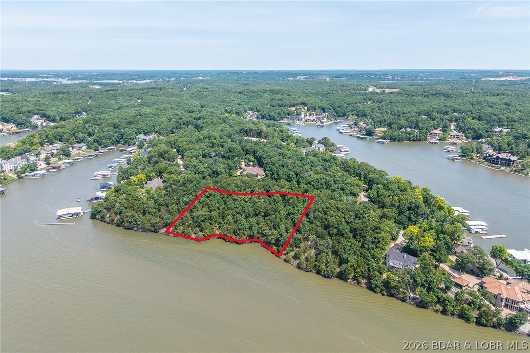 This premier Lakefront lot at The Villages at Shawnee Bend delivers the ultimate Lake of the Ozarks lifestyle with direct water access and breathtaking shoreline views. Arrive through the iconic grand waterfall entrance and enjoy a community known for its upscale amenities and attention to detail. Residents have access to a community marina, elegant clubhouse, multiple pools, championship tennis courts, and pickleball facilities, along with park and playground areas. With paved roads and underground utilities already in place, this lot is perfectly suited for a custom lakefront home with dock potential. A rare opportunity to own lakefront property in one of the lake’s most distinctive communities.