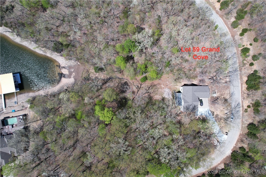 Feels like lakefront without the price! Spacious Lake view lot located in the Beautiful Community of Porto Cima. Perfect place to build your dream home! This lot features a fantastic Lake View with a green space/common area between the lot and the lake.... allowing you to have a nice lake view and any easy walk to take a swim in the lake or try your hand at fishing!  PLUS you have paved road to property with water and sewer hookup available, mature trees,  Great location with Four Season Amenities included - multiple community pools, pickleball, playground, tennis courts, campground, boat ramps and so much more! Check it out today!!