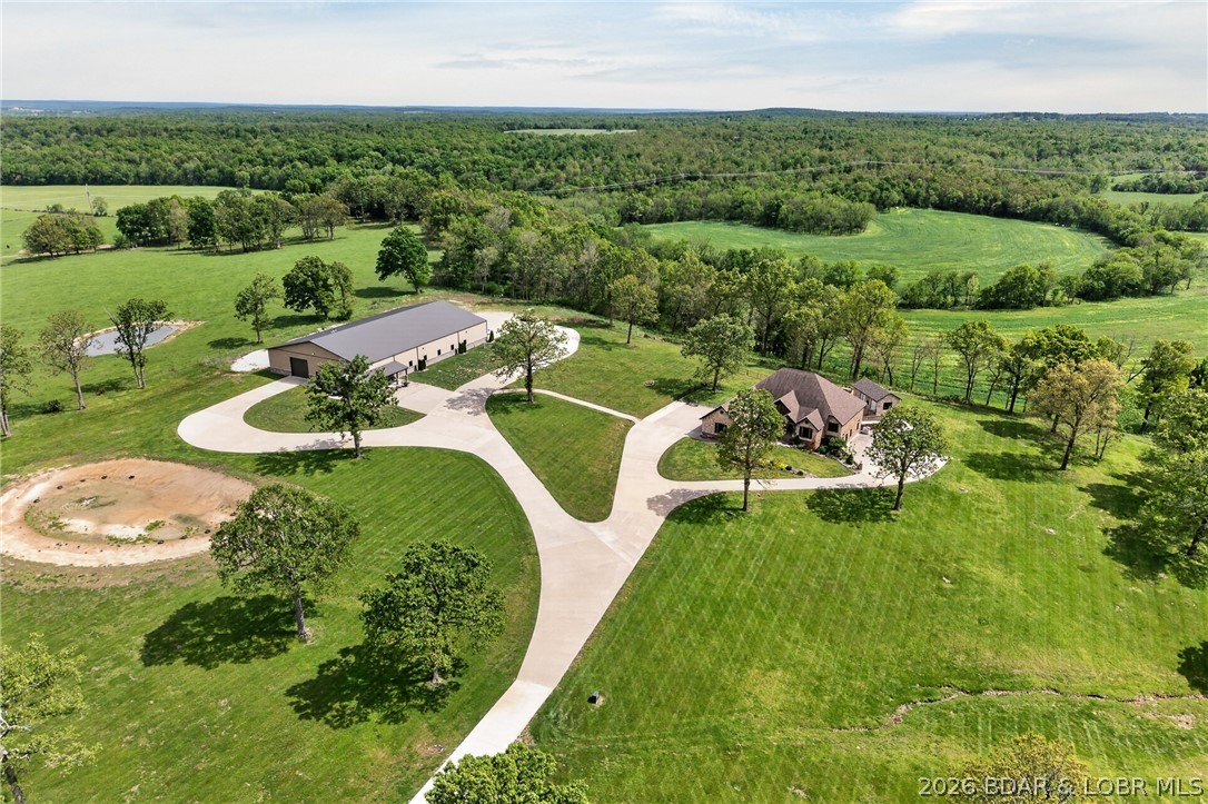 THIS is a ONE of A KIND PROPERTY and one of THE MOST BEAUTIFUL SETTINGS in THE AREA !! THIS CUSTOM BUILT HOME is SETTING ON 19.8 ACRES W/Large Scattered Trees, A POND. FULL BRICK & STONE HOME with fuLL finished WALK OUT BASEMENT, WONDERFUL VIEWS ,VERY OPEN CONCEPT LIVING and QUALITY IS THE WORD fromThe GROUND UP. New IN-GROUND POOL in 2023, NEW POOL HOUSE, This HOME HAS OVER 5400 SQ FT ML OF FINISHED LIVING SPACE, 3 CAR ATTACHED GARAGE. THE MAIN LEVEL OFFERS A LARGE LIVING ROOM W/FLOOR TO CEILING STONE FIREPLACE, Hardwood flooring throughout, Tile in The Baths, LARGE KITCHEN DINING AREA, CENTER ISLAND, GRANITE COUNTERS THROUGHOUT. A GREAT ENTERTAINING AREA, REAR COVERED PORCH, On the Main level has 3 BEDROOMS, 3 1/2 BATHS, HOME OFFICE,  DOG SHOWER ROOM. MASTER HAS A FIREPLACE, LARGE BATH W/CUSTOM TILE SHOWER, in all MAIN LEVEL BATHROOMS,  THEATRE AREA, VERY LARGE BAR, BEDROOM #4, w/ A FULL BATH, + 1/2 bath. W/urinal, SAFE ROOM. LARGEST HOME SHOP IN THIS AREA OVER interior 10,000. SQ FT w/SHOP space.11,620 sq ft w/porches, 2 LARGE OFFICES,  FULL BATH, LAUNDRY AREA, POLISHED CONCRETE FLOORS,14 FT OVER HEAD DOORS, COVERED PORCHES, 2- HVAC SYSTEMS in shop, New Shingles to be installed
