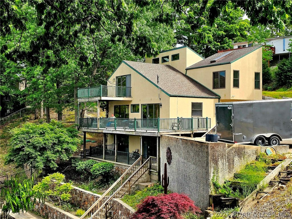 Recent remodel includes new kitchen, main level bedroom added, central vac, glass wall in master en-suite overlooking the living area, new carpet and LVP flooring. If your checklist includes stunning lake views, ample outdoor entertaining space and parking, room to sleep all your family and guests, large dock and slip, 200' of lakefront with deep water year round, moderate landscape, NO HOA, conveniently located to restaurants and shopping, then you will want to take a look at this great opportunity before someone else snatches it up. This 5 bedroom (2 primary suites) and 4 bath lake home is located at the Osage 10MM at the mouth of a large cove and offering beautiful main channel views. There is a 2nd tier lot included which provides additional parking or room to build another garage/shop. For those seeking additional investment or multi-family opportunities, the neighboring property is for sale MLS#3586847. Don't waste any time, call and schedule your private tour.
