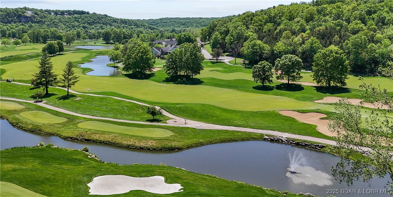 Tee up your dream lifestyle with this stunning golf course home! Fully furnished with 4 bedrooms and 4 full bathrooms, it sits along the 9th hole of the River Course at Osage National, Missouri’s only Arnold Palmer Signature Course. The view is one of the best in the community, stretching across fairways, greens, bright white Gulf Coast sand bunkers, a sparkling lake fountain, and all the way to the Osage River bluff. The main level has 10' ceilings with classic crown molding, and the lower level features heightened 9' ceilings. The kitchen includes 20" tile flooring and a sleek double drawer dishwasher. All rooms are generously sized, including an 800 sq ft family room with wet bar in the lower level, outfitted with unique Harley Davidson furniture. A north-facing covered deck and patio overlook this breathtaking, manicured setting. As one of only three single-family residences in Osage National approved for short-term rentals, this property is a rare investment opportunity. Enjoy 27 holes of exciting golf, an award-winning swimming pool complex, Eagle View Sports Bar & Grill, and a 24-hour fitness center. See MLS #3577686 for neighboring home also available.