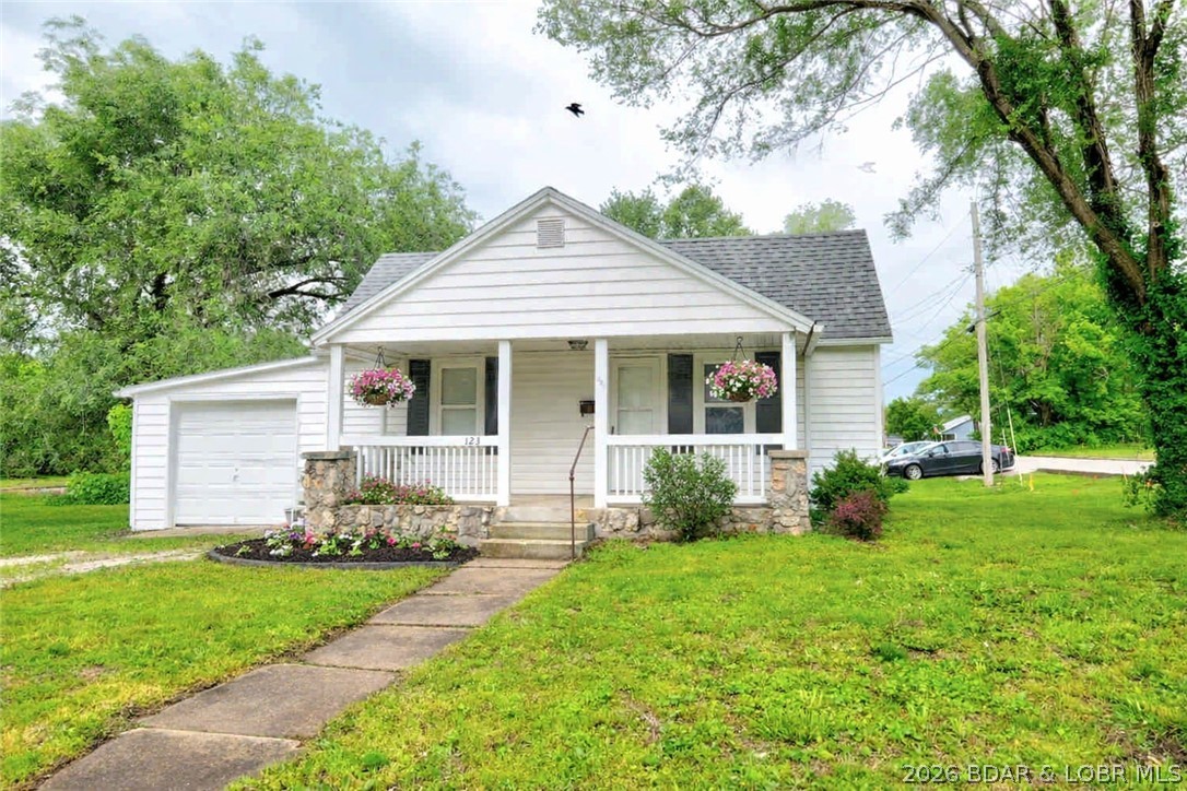Discover the perfect blend of character and comfort in this charming one-story, two-bedroom, one-bath home situated on a spacious corner lot. Step inside to a spacious living room and a nice sized primary bedroom, both showcasing original wood flooring, rounded archways, and the home’s signature rounded primary bedroom door with vintage glass knobs. The updated kitchen with stainless steel appliances, breakfast bar, and dining area offers generous space for cooking and gathering, kitchen has new vinyl flooring that adds a fresh, modern touch. A dedicated laundry room and an attached one-car garage add everyday convenience. Outside, enjoy the newly installed privacy fence that creates a secure, inviting backyard retreat. With a newer heating and cooling system, this home pairs timeless architectural charm with thoughtful updates throughout. A truly welcoming property ready for its next chapter.  *AI generated landscaping and hanging plants in first two pictures.