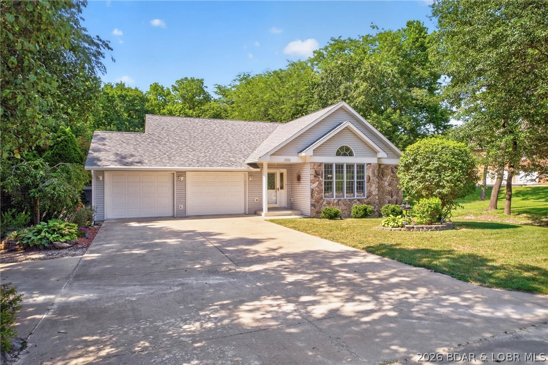 Welcome to Countryside Estates! This charming 4-bedroom, 3-bathroom home perfectly combines in-town convenience with a serene, country-like setting and no backyard neighbors. Step through the front door onto hardwood floors that flow into a light-filled living room featuring vaulted ceilings. The open-concept design seamlessly connects the galley kitchen and dining area, where glass doors open to a spacious bi-level deck ideal for outdoor hosting. Unwind while taking in tranquil wooded views, or host summer gatherings with ease on this expansive outdoor space. The main level features a primary en-suite with a jetted tub and walk-in closet, along with two generous bedrooms, a full bath, and main-floor laundry. Downstairs, the finished lower level provides the ultimate retreat with a spacious family room, wet bar, 4th bedroom, 3rd bath, and dedicated storage. Whether you are watching the big game or serving drinks at the bar, this lower level is built for memorable evenings. Complete with a rare 4-car garage setup (2 upper / 2 lower) for vehicles, workshop projects, or extra equipment, plus a private backyard fire pit area, this home offers space, storage, and effortless living!