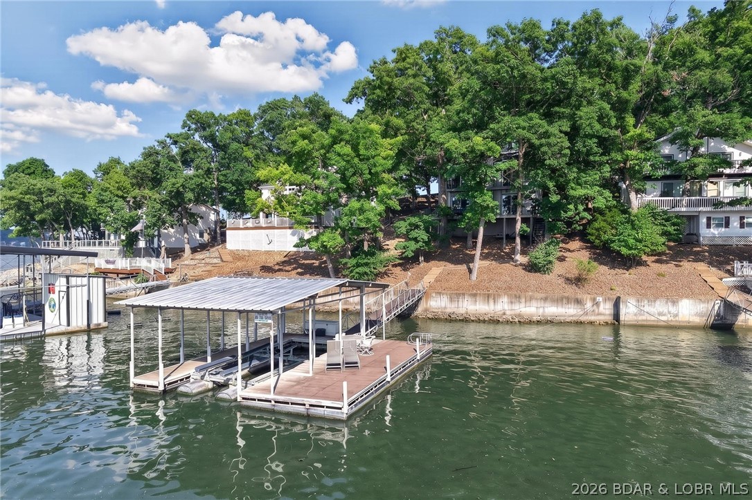 Lake Life, Elevated located at the 4MM of Lake of the Ozarks. Perfectly positioned at the 4-mile marker, just around the corner from the iconic Docknockers, this lakefront home delivers the ideal blend of fun, function, and flexibility. Step inside to one of the most sought-after floor plans on the lake featuring the main living area on the lower lakeside level. Whether you're hosting a weekend crowd or enjoying a quiet morning coffee, the flow of this home makes lake living feel effortless. With 3 bedrooms and 2.5 baths, every space has been thoughtfully updated. Fresh interior paint creates a bright, neutral canvas that is ready for your personal style to shine. Outside is where this home really comes to life: a sprawling deck made for cookouts, sunset gatherings, and long summer nights, plus abundant parking which is a rare and valuable find at the lake. Major updates? Already handled. Enjoy peace of mind with a brand new roof in 2025. Whether you're searching for a full-time residence, weekend escape, or investment opportunity, this property checks the boxes with location, layout, and lifestyle. Close to the action. Designed for the water. Ready for you.