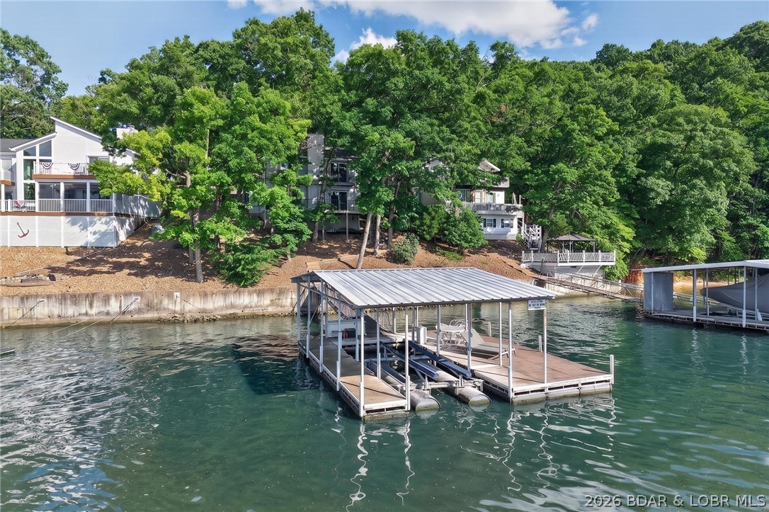 Lake Life, Elevated located at the 4MM of Lake of the Ozarks. Perfectly positioned at the 4-mile marker, just around the corner from the iconic Docknockers, this lakefront home delivers the ideal blend of fun, function, and flexibility. Step inside to one of the most sought-after floor plans on the lake featuring the main living area on the lower lakeside level. Whether you're hosting a weekend crowd or enjoying a quiet morning coffee, the flow of this home makes lake living feel effortless. With 3 bedrooms and 2.5 baths, every space has been thoughtfully updated. Fresh interior paint creates a bright, neutral canvas that is ready for your personal style to shine. Outside is where this home really comes to life: a sprawling deck made for cookouts, sunset gatherings, and long summer nights, plus abundant parking which is a rare and valuable find at the lake. Major updates? Already handled. Enjoy peace of mind with a brand new roof in 2025. Whether you're searching for a full-time residence, weekend escape, or investment opportunity, this property checks the boxes with location, layout, and lifestyle. Close to the action. Designed for the water. Ready for you.