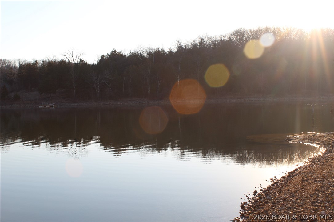 PRISTINE LAKEFRONT LOT ON PRIVATE POCAHONTAS LAKE! Lot 46 offers approximately 89 feet of shoreline on a peaceful, spring-fed lake. Because this lake is spring-fed, you enjoy consistent water levels and NO winter drawdown, ensuring your dock and views are perfect year-round. This tiered lot provides a natural footprint for a small cabin or a leveled camper pad with an incredible view across the water. Step down to your private gravel beach area, ideal for swimming, fishing, or launching a kayak right from your own property.

This lot is the second half of our premier double-lot listing—buy just this piece for a private escape or ask about Lot 47 to secure the full 182 feet of frontage! Ownership includes elite community amenities: a campground, playground, and community dock. For hunters, there is a dedicated resident-only hunting area. Practical features include on-site showers, a camper dumpsite, and even boat access to the Lake of the Ozarks for bigger water adventures. Fully stocked and ready for summer, this spring-fed lakefront is priced for a quick sale. Don't miss out on the best stable water in the area!