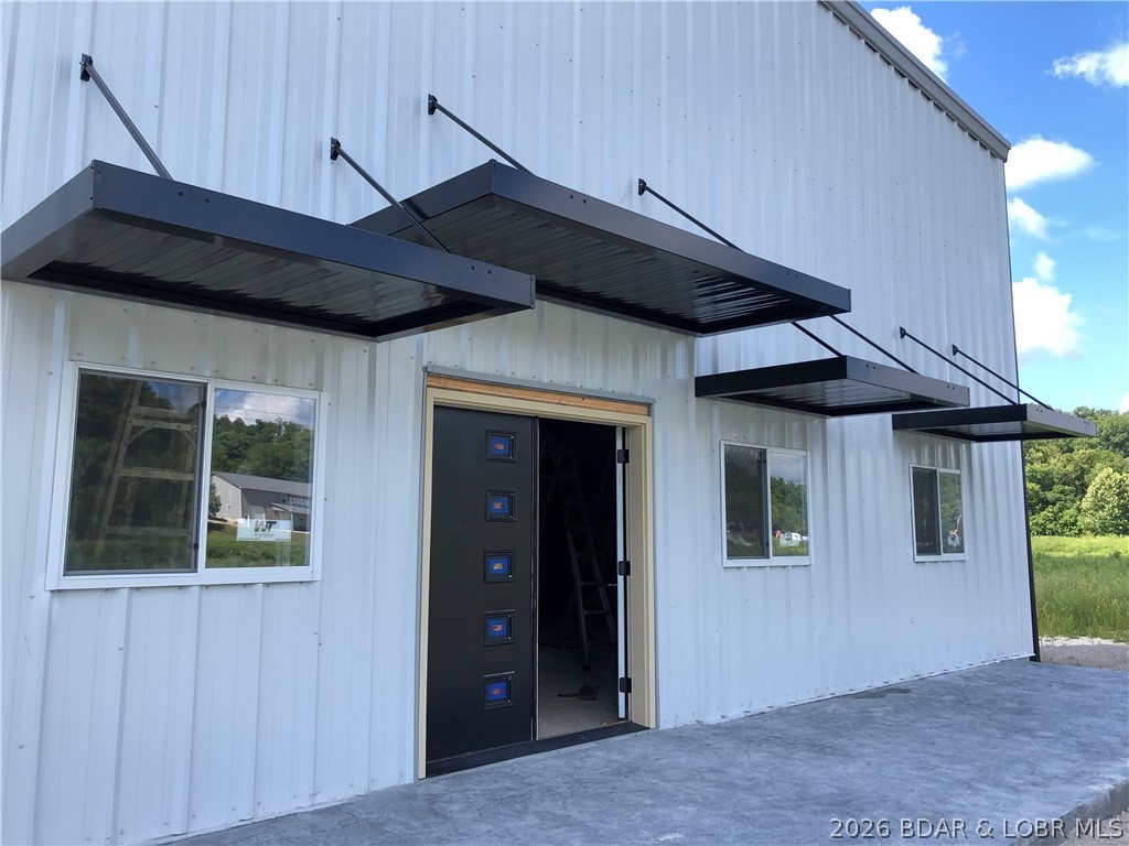 Only ONE 5,000 sq ft. Industrial Bldg or Man Cave/Warehouse space remaining just minutes from Lake Ozark and Osage Beach, conveniently located right off Highway 54. Prewitt's Industrial Park features numerous options to suit any buyer. NO ZONING or county restrictions, which allows for industrial, storage or most any use for this property with approval from the developer.  This unit is 5,000 sq. ft. with ceiling heights of 20 foot high and two large Overhead doors (16ft wide by 18 ft. high) with an entrance door with windows for natural light. Included amenities are 1,000 sq ft office, stubbed for bathrooms, concrete floors with floor drains, HVAC, LED lighting, all R-19 insulation, 8ft interior liners, trash, water, sewer, RV dump, cleanout stations, exterior lighting, paved roads and landscaping. Call for build to suit options. Secure the last spot today!  Three Phase Electric available.