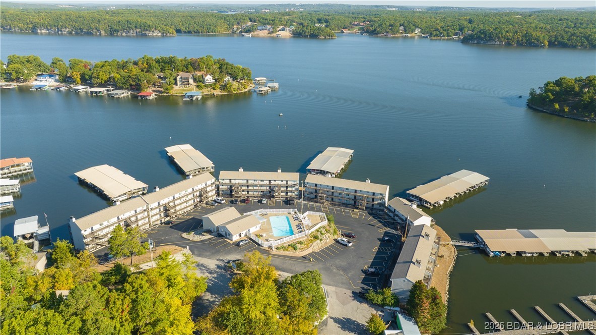 UPDATED TURNKEY CONDO in OUTSTANDING OSAGE BEACH LOCATION - This fully updated, turnkey condo is located in a protected cove, yet offers a massive main channel view from the expansive deck.  The kitchen has been fully renovated with all new cabinets, butcher block counter tops, gorgeous tile backsplash, appliances, sink, and fixtures, and an open layout allows for a lake view from the kitchen, dining area, living room and primary bedroom.  The unit is crisp and clean with new paint, trim, doors and LVP flooring throughout, and a fully renovated bathroom includes new vanity, sinktop, fixtures, tile flooring and tiled tub surround. The elevated pool with clubhouse provides a nice lake view and the complex is located right next to Shorty Pants, so you are able to just stroll next door to grab a bite to eat or get your party started. This location is so convenient to everything you want and need and allows for quick access by land or water to an abundance of shopping and favorite off-water and lakefront restaurants.  Now is the time to secure your Lake Getaway before the season begins, or get started with a rental investment property.
