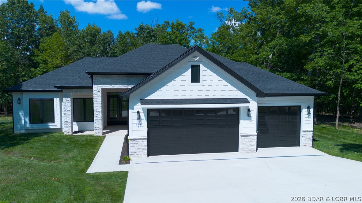 NEW CONSTRUCTION in Porto Cima! This modern ranch delivers the quality, design & lifestyle today’s buyers are looking for—all on a flat lot just steps from the golf course cart path. Walk out the front door and you are within walking distance of the world-famous course, or take a short golf cart ride to the clubhouse, restaurant, pool, courts & marina. Effortless one-level living, this 3-br, 2.5-bath home includes an office, 3-car garage and zero-entry access with no steps throughout. The striking exterior combines stone, cement board siding, black windows, irrigated sod yard and clean modern lines. Inside, 8' doors, tall ceilings, beautiful flooring and a dramatic linear fireplace completely surrounded by stone create an upscale comfortable atmosphere. The floorplan features a stylish drop zone off the garage, spacious laundry room with cabinetry & a gorgeous kitchen. The large primary suite is a true retreat with heated tile floors, soaking tub, custom tiled shower & closet system. Enjoy a screened patio plus an open patio overlooking the level yard. Sonos surround sound, Ring cameras & thoughtful upgrades throughout. High-end, move-in ready and Porto Cima!