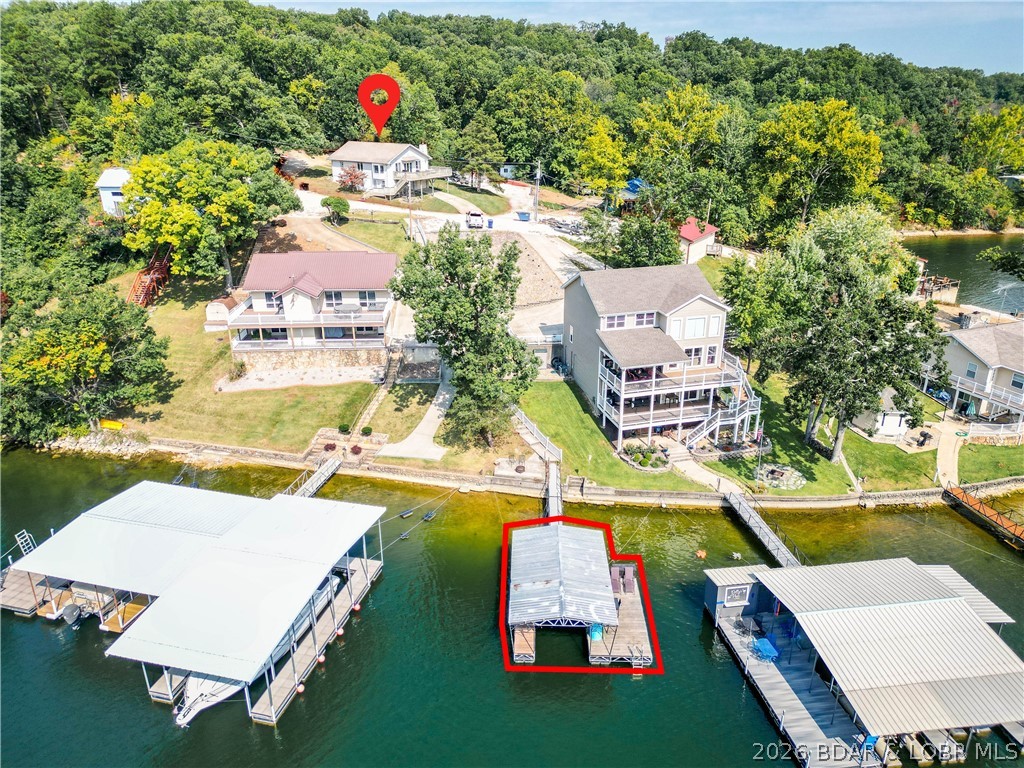 Your lake escape is waiting! Perfectly positioned on a second-tier lot with breathtaking lake views and the bonus of your own private dock, this property is ready to make every weekend feel like a vacation. Spend your days swimming, fishing, boating, or simply relaxing on the oversized deck while taking in the peaceful water views.  Designed with entertaining in mind, the home offers plenty of space for family and friends, along with ample parking for guests. The attached one-car garage has been transformed into a fun gathering space for game days, evening cocktails, or get-togethers, while still offering the flexibility to easily convert it back into a garage if desired.  A brand-new septic system is being installed, giving you one less project to worry about. Located in a protected cove at the 4 Mile Marker, you'll enjoy calmer waters with quick boat access to many of the Lake's favorite waterfront restaurants and attractions. Best of all, this home is being sold fully furnished, making it truly move-in ready so you can start enjoying lake life from day one.