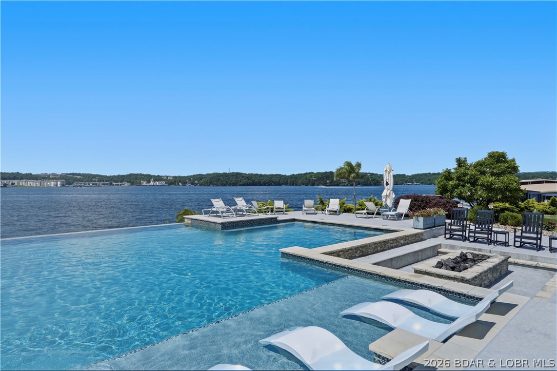 Experience luxury lakefront living at The Cypress, one of Lake of the Ozarks' premier waterfront communities. This Club Level condo features the second-largest floor plan and an expansive nearly 900 sq. ft. balcony with panoramic main channel views in multiple directions. The reconfigured kitchen offers enhanced workspace and flow, while the living area showcases a floor-to-ceiling stone corner fireplace. The primary suite includes heated bathroom floors, tiled showers, and premium finishes throughout. Additional upgrades include Hunter Douglas blinds, upgraded bedroom carpet, custom built-in desk, trimmed storage and utility spaces, Wi-Fi-enabled water heaters, and added blown-in insulation for enhanced sound reduction. Sold furnished with new Beautyrest Black mattresses, this turnkey property also includes a 16x44 boat slip, PWC slip WITH Yamaha WaveRunner, and a reserved parking space. Located on the waterfront with convenient access to golf, dining, entertainment, and all that Lake of the Ozarks has to offer, this is an exceptional opportunity for a full-time residence or luxury lake retreat