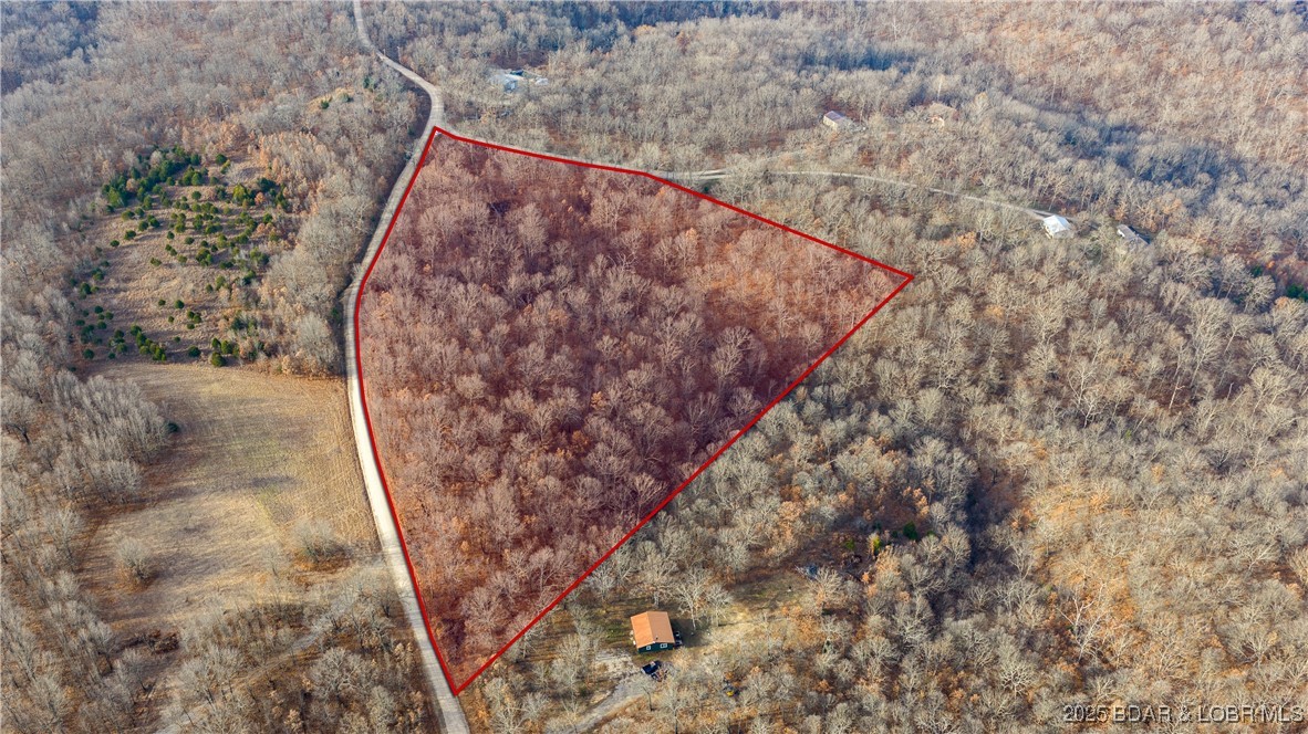 Discover the privacy and potential of this approximately 10.58-acre wooded tract located within the gated Tonka Springs Ranch subdivision in Eldridge, Missouri. Offering a peaceful Ozarks setting with mature timber, rolling terrain, and potential building sites, this property is ideal for a future homesite, private retreat, or long-term land investment. With over 550 feet of road frontage along Maverick Drive, the property provides convenient access while maintaining a secluded feel. Tonka Springs Ranch features parcels that preserve privacy and the community's natural character. Recorded restrictions allow residential and agricultural use with a minimum 1,000 sq ft home requirement. Located near Bennett Spring State Park, enjoy access to fishing, hiking, and outdoor recreation while remaining within driving distance of Lebanon and I-44. Electric service is available at or near the road. Water and sewer are not installed. Whether you're looking to build now or secure acreage for the future, this gated Ozarks property offers an opportunity to own over 10 acres in a quiet rural setting. Buyer to verify acreage, utilities, restrictions, and suitability for intended use.