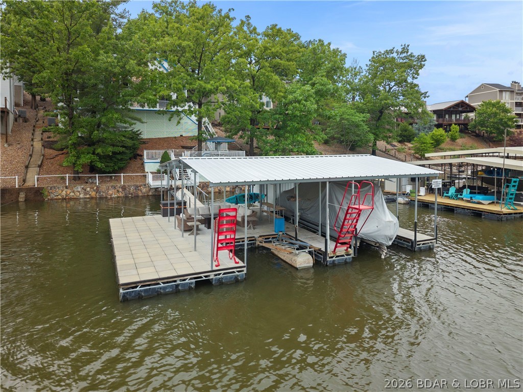 Discover a rare opportunity to own a truly distinctive lakefront retreat that breaks the mold of the typical modern lake home. This spacious 4-bedroom, 3.5-bath home is filled with character, timeless charm, and unique architectural details throughout, offering the perfect canvas to bring your personal vision to life. With great bones and an inviting layout, this property is ideal for entertaining and making lasting lake memories.

The oversized master suite is a true escape, featuring a massive bedroom and an expansive en-suite bath complete with a large soaking tub and walk-in shower. Enjoy 3 levels of entertaining space, including a private lower-level bedroom perfect for guests, a sauna, one-of-a-kind bar area, and a stunning floor-to-ceiling stone fireplace that anchors the main living area.

Step outside to the spacious back deck and soak in beautiful lake views. The brand-new covered and uncovered dock features 2 boat wells and easy water access. Located in a protected cove within the State Park, you’ll enjoy privacy, calm waters, and an unbeatable lake setting. Garage included for extra storage and lake essentials.