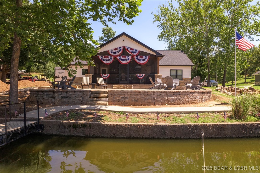 Amazing newer one level home in a quiet protected cove!  This house checks all the boxes if you are looking for a ranch style home with a flat driveway and gentle to the beautiful Lake of the Ozarks.  Pristine home that is Scrubby Dutch Clean with a gorgeous lakeside screened deck that will knock your socks off! Just a couple steps to your 12x34 boat slip, this is exactly what the doctor ordered.  Amazing lakeside deck with the fire pit of your dreams. Getting on the water can't be any easier. Imagine having a 3 car garage, plenty of parking, bathroom that is accessible from the garage and much more! Rare development with water and sewer for the community. A 16x34 boat slip is available to purchase for $25,000.  Don't miss this one-off-a-kind lakefront dream come true home.