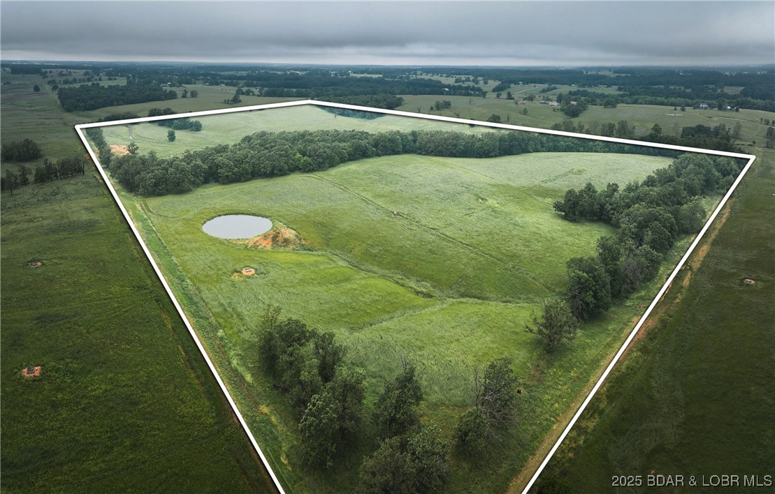 This 66+/- acre tract offers a perfect blend of natural beauty and practical functionality. Located in Barry County, the land features a flowing creek, a tranquil pond, and blacktop road frontage on one side. Gently rolling topography with rich grassland and scattered trees makes it ideal for livestock, building, or recreational use. Solar-powered electric fencing is already in place. No zoning or restrictions allow you to build your dream home, establish a farm, or develop the property to suit your needs. Private, yet just minutes south of Walmart and within easy reach of Springfield, Branson, and Aurora. Properties like this are hard to find—secure your piece of the Ozarks today!
