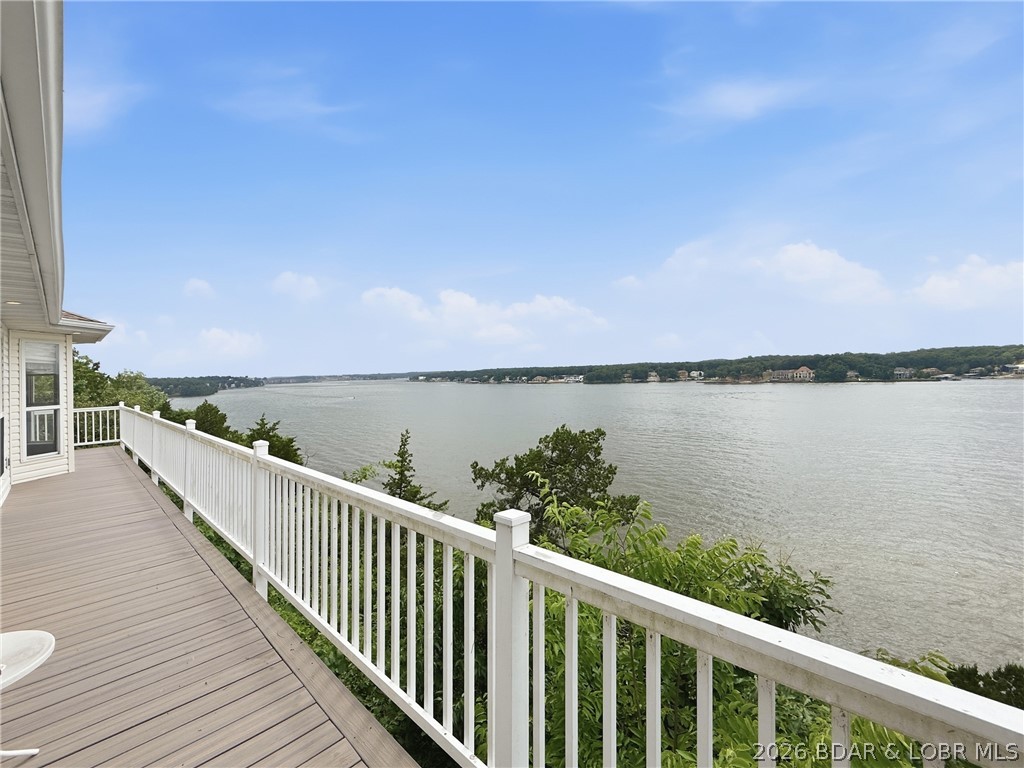 Perched on a bluff in the heart of Osage Beach, this one-owner home offers the kind of million-dollar lake view buyers dream about! Featuring 3 bedrooms, 3.5 baths, and true main-level living, this home has been lovingly maintained and is ready for its next chapter. The spacious primary suite includes a recently remodeled bath with a luxurious soaking tub, while the lower-level bath has also been beautifully updated. New carpet (within the past year), a new furnace (2017), heated and cooled sunroom with new tile, and composite decking add comfort and value. The oversized 2-car garage includes an incredible amount of storage with a full staircase leading to the attic space above. The large kitchen offers abundant cabinetry and workspace, ready to enjoy as-is or customize to your style. Outside, enjoy the charming gazebo/greenhouse, community dock with a 10x24 boat slip, and an unbeatable location just minutes from shopping, entertainment, and popular lakefront restaurants. Nightly rentals are allowed, making this an excellent investment opportunity or full-time lake retreat!