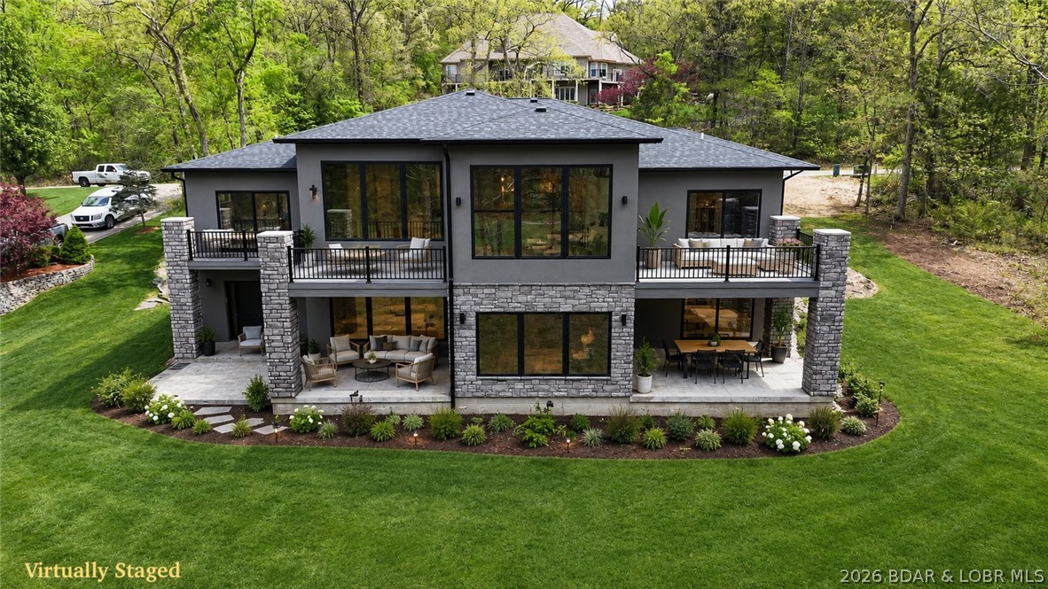 Brand-new construction in the highly sought-after Old Kinderhook community, perfectly positioned on the 3rd hole of the golf course. Designed with quality craftsmanship and thoughtful upgrades throughout, this home offers a level driveway, oversized 3-car garage, and an additional lower-level garage ideal for a golf cart, workshop, storage, or future pool house. The open main-level floor plan features a stunning great room with soaring ceilings and an impressive fireplace, a beautifully designed kitchen with custom cabinetry and upgraded appliances, plus a spacious dining area with easy access to the large deck for entertaining and grilling. The main level also includes two suites, a dedicated office or possible fifth bedroom, full laundry room, and half bath. The walkout lower level offers a large family room with stone fireplace and plumbed wet bar area, two additional bedroom suites, generous storage, and utility space. Concrete patios lead to the oversized golf cart garage/workshop. Large level yard ideal for a future pool, fire pit, and outdoor fun. Old Kinderhook amenities included. 400-amp service. Conveniently located near dining, marina access, and resort-style amenities.