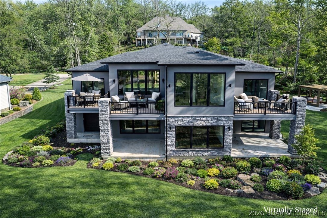 Brand-new construction in the highly sought-after Old Kinderhook community, perfectly positioned on the 3rd hole of the golf course. Designed with quality craftsmanship and thoughtful upgrades throughout, this home offers a level driveway, oversized 3-car garage, and an additional lower-level garage ideal for a golf cart, workshop, storage, or future pool house. The open main-level floor plan features a stunning great room with soaring ceilings and an impressive fireplace, a beautifully designed kitchen with custom cabinetry and upgraded appliances, plus a spacious dining area with easy access to the large deck for entertaining and grilling. The main level also includes two suites, a dedicated office or possible fifth bedroom, full laundry room, and half bath. The walkout lower level offers a large family room with stone fireplace and plumbed wet bar area, two additional bedroom suites, generous storage, and utility space. Concrete patios lead to the oversized golf cart garage/workshop. Large level yard ideal for a future pool, fire pit, and outdoor fun. Old Kinderhook amenities included. 400-amp service. Conveniently located near dining, marina access, and resort-style amenities.