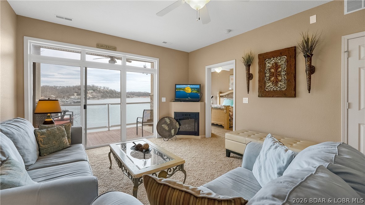 Welcome to effortless lake living in this small, private complex, perfectly positioned at the mouth of a protected no-wake cove on the Niangua—offering the rare combination of calm waters and sweeping main channel views. Pointe Royale offers the convenience of an elevator and boat ramp, and a beautiful pool overlooking the Niangua. This meticulously maintained condo is bright and inviting with tall ceilings, upgraded finishes, and stainless steel appliances that complement the open living space. Expansive windows frame beautiful lake views and lead directly to the covered concrete deck, creating the perfect place to relax, entertain, or unwind after a day on the water. Both bedrooms are generously sized, with the primary suite featuring stunning views, private en-suite bath and walk-in closet. Best of all, the condo is offered turn-key, making it truly move-in ready to begin enjoying the Lake immediately. Just minutes from town and some of the lake’s favorite waterfront spots including The Cave, NautiFish, and Captain Ron’s. Whether you're enjoying quiet mornings on the deck or watching boats pass in the distance, this exceptional property captures the best of the Lake lifestyle.