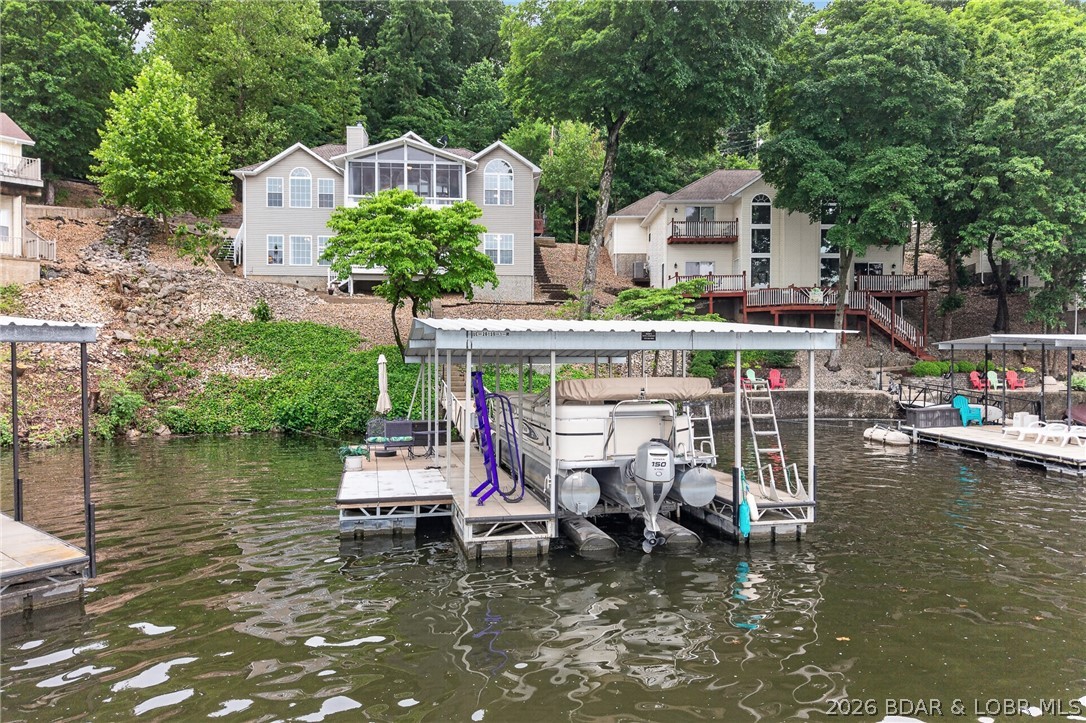 Nestled in the coveted Diamond Head subdivision along the quiet, deep waters of Little Niangua,this pristine home delivers the lake lifestyle without compromise. Functional floor plan is ideal for full time or hosting lots of family complete w/ a heated& cooled three seasons room overlooking the lake. Deep, calm water perfect for crappie fishing right off your own concrete dock sets the tone for everything here:easy,refined, & move-in ready.Inside,generous open living spaces frame beautiful lake views,and an updated kitchen features stainless appliances,a convection oven, quartz countertops, and Pergo flooring. Storage abounds throughout. Outside, lighted walkways lead the way,and low-maintenance landscaping and exterior mean more time on the water. The shared access road means fewer stairs to the dock a detail boaters genuinely appreciate. Central sewer, quiet cul-de-sac feel, and the prestige of Diamond Head address round out an offering that's hard to match at any price point.
Seller includes a one-year home warranty for added peace of mind.Your lakefront chapter starts here.