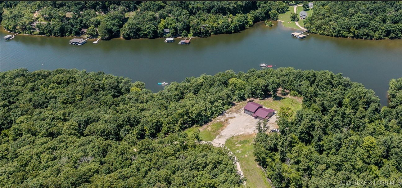 Spacious 1.20 acres and 80' of lakefront in a reg no wake cove. Main level living, Main BR patio is wired for a hot tub. Main BA, enjoy custom walk-in shower, bidet, huge 10'x15' walk-in closet.  Ceiling fans though out!  A gourmet kitchen, with quartz counter tops, walk-in pantry. Laundry mud rm., equip. to bathe pets-wash-up those kiddoes after playing outdoors! Extra storage/closet space & area above drop ceiling in 2.5 car garage area (732 sq. ft.) in addition to the fin. sq. ft. Parking avail for 15+ vehicles, RV 110 electrical hookup.  Garage has a mini splitter Heater/AC adding comfort during projects! Sellers offering $10,000. credit allowance toward pro landscaping. Tax bill is from a larger parcel, therefore tax bill is to be determined. Property lines are approximate; are for illustration purposes only; Additional shoreline avail. for X $$'s see MLS#3576825.  Full time occupied; scheduled appointment a 4-hour notice to see. Please' No drive by (private rd.). Cameras-video in use. Trustee for the trust is a licensed real estate agent.
